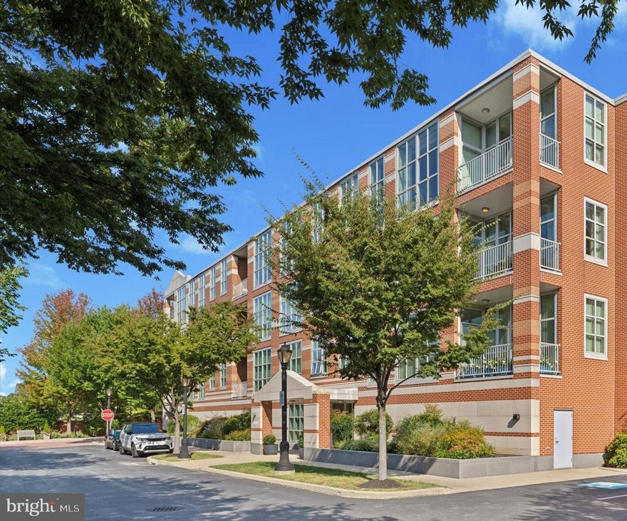 A walkable Wayne, low maintenance lifestyle awaits, in this elegant sunlit corner unit with a gracious balcony overlooking the tree tops, perfectly situated in the highly sought-after Pembroke North community. This peaceful and spacious 2-bedroom, 2.5-bath residence offers 1,847 square feet of beautifully finished living space, thoughtfully and luxuriously finished & designed as the model unit, with an open floor plan, floor-to-ceiling windows that fill the home with natural light, soaring 9+ foot ceilings, and beautiful hardwood floors and moldings. The gourmet kitchen is a true centerpiece, featuring a dramatic 7-foot island with seating for four, rich wood cabinetry, leathered granite counters, sleek marble backsplash, GE Monogram stainless appliances, and a built-in wine fridge - ideal for both everyday living and entertaining.
The living area is enhanced by custom-built-in cabinetry, custom automated window coverings, and the dining area with designer light fixtures seamlessly blends into the space and opens to a private balcony, perfect for morning coffee or evening relaxation. Both bedrooms are generously sized, including a luxurious primary suite with two custom outfitted closets, a limestone spa-inspired bathroom, with an oversized frameless glass-enclosed shower, and double vanity with plenty of storage. Additional highlights include a large entry foyer with powder room and coat closet, Lutron smart blinds, hardwood floors throughout, a dedicated laundry room with pegboard, a private HVAC, High-efficient windows and well insulated walls and ceilings result in surprisingly low energy bills. 
This unit also includes secure, indoor heated garage parking and a private storage area. The building’s association fee covers common area maintenance, building exterior, snow and lawn care, trash, water, sewer, parking, insurance, alarm system, and on-site professional management & maintenance, making for truly low-maintenance living. Ideally located in the award-winning Radnor School District and just a short walk to downtown Wayne’s shops, restaurants, cafes, and two train stations. 125 Iron Works Way offers the perfect blend of luxury, convenience, walk-to-Wayne easy lifestyle close to the grocery store, library, schools, the Wayne Art Center, the Radnor Trail, Chanticleer Gardens, and conveniently located for quick access to I-476, Route 202 and PA turnpike.