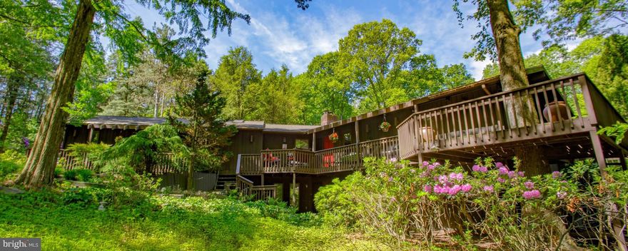 Tucked away in a peaceful, private setting, this one-of-a-kind  New England Style home offers a perfect blend of style, comfort, and natural beauty. From the moment you arrive, you're greeted by a professionally landscaped yard filled with over 60 blooming rhododendrons, mature pine trees, and diverse plantings that transform the grounds into your very own botanical retreat.

Inside, the home impresses with striking architectural design, featuring vaulted ceilings and oversized windows that flood the space with natural light. Two dramatic brick fireplaces serve as the heart of the living area, creating warmth and character throughout the home. The first floor includes a spacious primary bedroom with a full bath for convenient one-level living. A standout feature is the all-season sunroom, which includes a large indoor spa, adding to the home’s resort-like atmosphere.

Downstairs, the fully finished lower level offers even more living space, including two additional bedrooms, a dedicated office, a fitness room, abundant storage, and multiple flexible spaces perfect for entertaining or relaxing.

This property is truly unlike anything else—combining contemporary design, thoughtful layout, and lush surroundings into a home that’s both stylish and serene. Professional photos are coming soon, but this is a property that must be experienced in person to be fully appreciated.