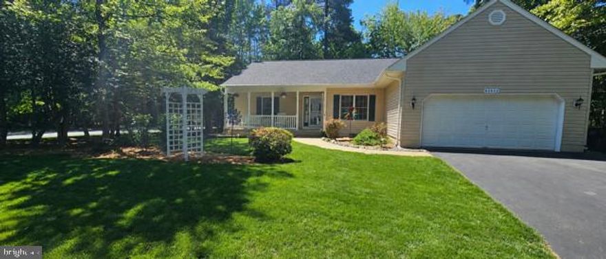 Welcome home to this beautifully maintained rambler with an open floor plan, ideally situated on a quiet cul-de-sac and landscaped corner lot. Offering 4 bedrooms and 2 full baths, this home features heated ceramic tile flooring in the bathrooms for added comfort and luxury. The spacious family room boasts cathedral ceilings and a cozy gas fireplace, flowing seamlessly into the large kitchen with ceramic tile flooring, an eat-in area, and a dedicated formal dining room with French doors - perfect for entertaining. 
Fourth bedroom, off foyer, can also be utilized as a private office/study.  An ideal flex space for working from home! The primary suite offers a large walk-in closet, dual vanities, and heated ceramic tile flooring in the primary bath. Hardwood flooring runs throughout much of the home, with fresh paint and new carpet recently installed in 2 of the 3 bedrooms. Enjoy outdoor living on the large rear deck or covered front porch overlooking the beautifully maintained lawn complete with an irrigation system. Additional highlights include a 2-car attached garage with floored storage space above the garage. Major updates include a new roof installed in November 2022, along with a new HVAC system and hot water heater installed in 2020. Conveniently located close to schools, restaurants, and shopping, and just minutes to PAX NAS!