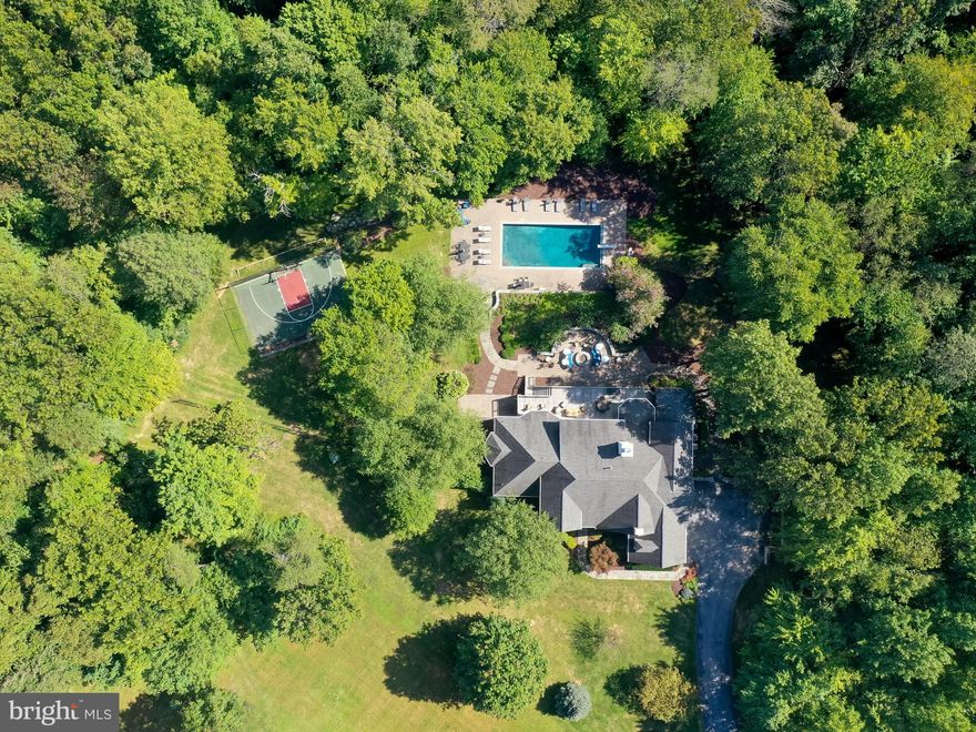 Paradise awaits in this resort style home in a picturesque & private setting.  Classic architecture combined with amazing modern amenities, this home has it all and is in move in ready condition.  All the light oak floors have been refinished, and has been freshly paint throughout.  A very modern and clean aesthetic has been achieved with these recent updates.  Truly gorgeous and current vibe! Light streams into all rooms including the above grade lower level which walks out to the patios and pool.  Four En suite bedroom with bathrooms on the upper level and a main floor primary suite with access to an owner's office space.  The lower level is a stay-cation in itself with a home gym, game room, tv family room with full bar and temperature regulated wine room.  There is a 6th bedroom option in the lower level with a full bath so ideal for a relative, caretaker or guests.  Three fireplaces - 2 wood burning on the main level and gas in the lower level, an outdoor wood burning firepit, with propane heated lamps are included with the sale. This property is rich with amenities perfect for entertaining or just enjoying privately.  Also stunning in the evening with automatic lighting surrounding the pool and property.  An oasis close to the conveniences off of 795, the Owings Mills Town Center, Wegmans, Home Sense, Costco and more.  Close proximity to all major roads and the Maryland countryside.