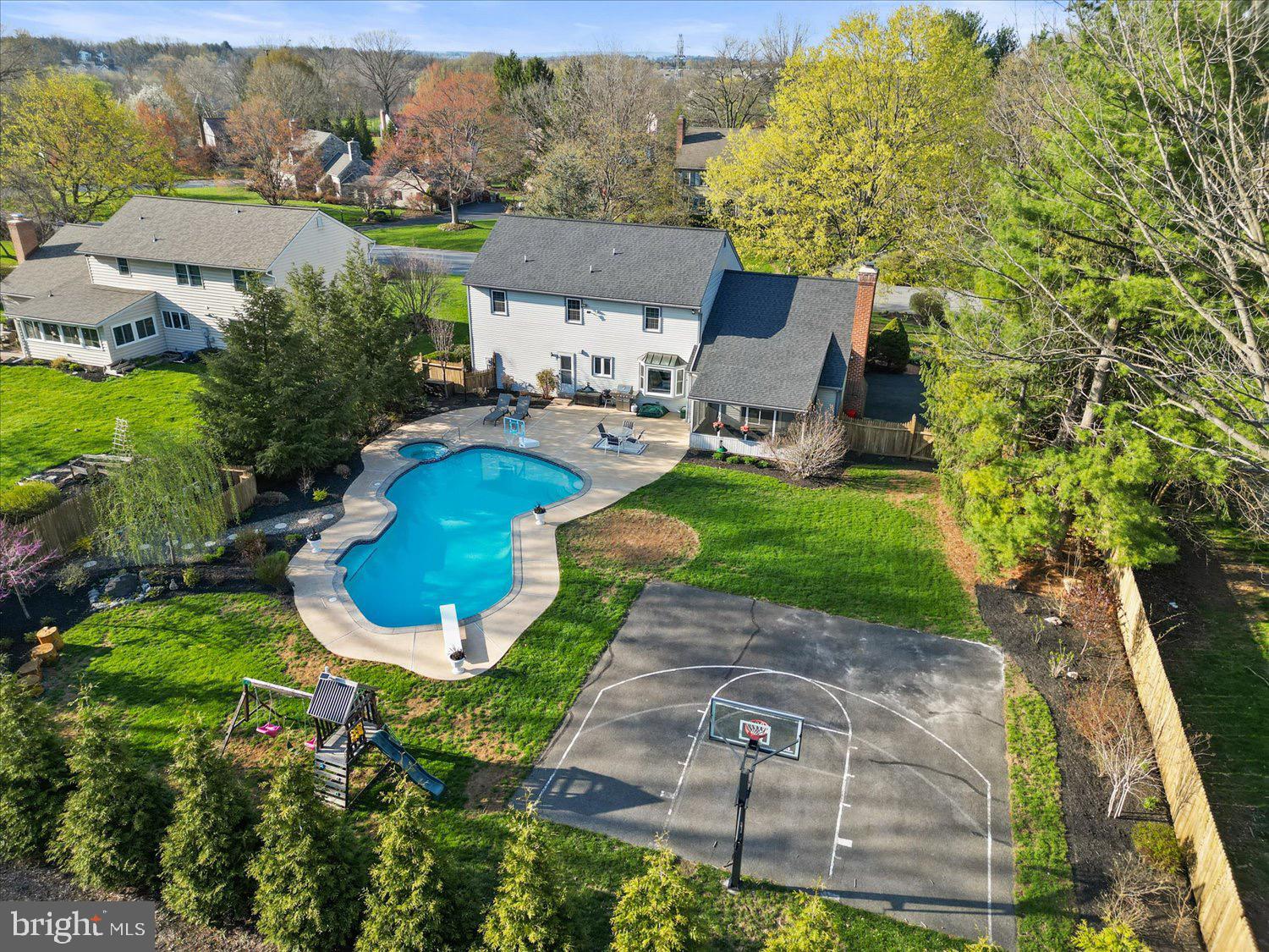 This backyard is an entertainer’s dream. Welcome to this stunning home nestled in the highly desirable Wetherburn neighborhood of Manheim Township. Set back beautifully from the street and surrounded by mature trees, this property offers the perfect blend of privacy, charm, and functionality.
Step inside and you'll find a bright, open-concept kitchen and living room with a cozy bay window and built-in bench — the ideal spot to enjoy your morning coffee while watching poolside fun or maybe a competitive basketball game outside. The spacious sunroom is your go-to for rainy evenings, offering comfort and tranquility year-round. Heading out back, your personal oasis awaits: an incredible heated saltwater pool with an attached hot tub, plus your very own basketball court featuring a brand-new Goalrilla hoop — perfect for entertaining or keeping the kids active.
This lovely home also features a side-loading garage for great curb appeal, a real wood-burning fireplace in the living room, and a versatile bonus room on the first floor that makes a perfect home office. Upstairs, you'll find four spacious bedrooms, including a primary suite with a newly renovated en suite bathroom.
This is the kind of home where memories are made. Don't miss your chance to make it yours.