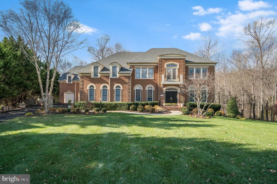 This exceptional property is the epitome of luxury living, set on a lush 1.77-acre lot that backs to wood-preserved land, ensuring privacy and tranquility. With over 10,700 square feet of exquisite living space, this prestigious home offers a lifestyle of unparalleled elegance and comfort. Boasting a 5-car garage, 6 bedrooms, 6 baths & 2 half baths, and numerous opulent features, this home is a testament to fine craftsmanship and attention to detail. The layout includes 2 luxury owner suites, ensuite bedrooms, a living/eat-in in-law suite, and so much more. The heart of the home is the gourmet kitchen, a culinary masterpiece with top-of-the-line appliances. The morning room is a delightful space for casual dining and a sun-soaked sanctuary. The lower level offers endless possibilities with a second family room, exercise rooms, and ample storage, making it ideal for entertainment and relaxation. Step outside and discover a stunning deck overlooking the large backyard with paths leading to a picturesque creek. This outdoor oasis is perfect for hosting gatherings, enjoying nature, and relaxing. The home is flooded with natural light thanks to its abundance of windows, creating a warm and inviting atmosphere throughout, and would be Ideal for a multigenerational family. Situated in the sought-after Running Creek subdivision, this property offers both seclusion and convenience. It's near shopping and retail centers and provides easy access to I-95, making for a quick 35-minute drive to Washington, D.C. Indulge in the extraordinary lifestyle this Buckingham model home offers. Don't miss the opportunity to make this grand estate your own. Schedule a showing today and experience the pinnacle of luxury living.