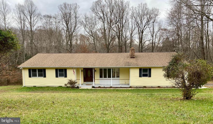 Welcome Home! Looking for one level living in a serene and relaxing setting? Look no farther. Situated on 3 acres, this private location bordered by Zekiah Natural Environmental area is perfect.  As you enter from the front porch, the large open floor plan boast of character and features updated flooring throughout. The living room’s fireplace is perfect for those cold nights and a beautiful bay window brings in lots of natural sunlight. The large dining area is great for entertaining and you can enjoy the view of the trees from the covered porch/deck.  Enter the large sunroom with ceiling fan and 3 large windows that embrace the natural sunlight and the beauty of the trees. The sunroom has a small deck and entrance off side of home. The kitchen has a breakfast bar, updated appliances, wall oven, double sink , dishwasher, side by side refrigerator with icemaker, ceiling fan and gas cooktop stove. The laundry room is off the kitchen and has a front load washer and dryer. You can also go on the rear covered porch/deck from the laundry room.  Go down the hallway to 4 bedrooms that have updated carpet and ceiling fans. The primary bedroom has large walk-in closet, and full bath with shower. Hallway main bathroom’s space is large and maybe able to assist those that need additional space for mobility.  Need space for parking? Home has single garage door but garage is large enough for two cars or car and workspace.  The edge of the property line goes to a stream.