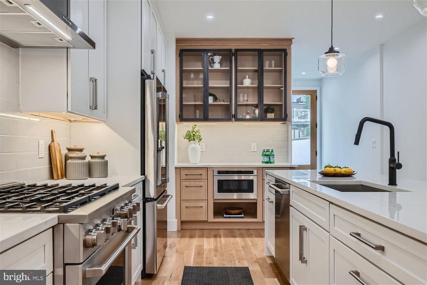 Presenting an impeccably renovated four-level contemporary rowhouse in Canton, crafted to perfection by Blueprint Development. Boasting 3,000 square feet of refined living space, this residence features four bedrooms, four full and one half bathrooms, a rooftop deck, one-car garage, and the sought-after CHAP tax credit. The open floor plan exudes sophistication with 9-foot ceilings, exposed brick, recessed and designer lighting, and stunning white oak hardwood floors throughout. The main level encompasses a spacious living/dining room, chef's kitchen, mudroom, wet bar, powder room, and access to the private courtyard. The Chef’s kitchen showcases an expansive quartz waterfall island, subway tile backsplash, and top-of-the-line appliances. Upstairs, the second floor hosts two bedrooms, two full baths, and a laundry area, while the third floor offers a luxurious primary bedroom suite, den area, and additional bonus/storage space. Retreat to the illuminated primary bedroom featuring a spacious walk-in closet and en-suite spa bathroom with a double bowl quartz vanity and oversized marble frameless walk-in shower. The den provides flexible usage, ideal for an office, nursery, or entertainment area, conveniently situated adjacent to the primary bedroom and rooftop deck. The finished lower level provides a fourth bedroom or bonus room with a full bathroom. Step outside to the rooftop deck for mesmerizing city, harbor, and sunset views. Located in one of Canton's premier blocks, this residence offers unparalleled convenience, with easy access to Canton Square, parks, waterfront promenade, retail shopping, and major highways. Approval pending, a 10-year CHAP tax credit enhances the value of this exceptional property. Experience elevated living in one of Canton's most coveted neighborhoods.