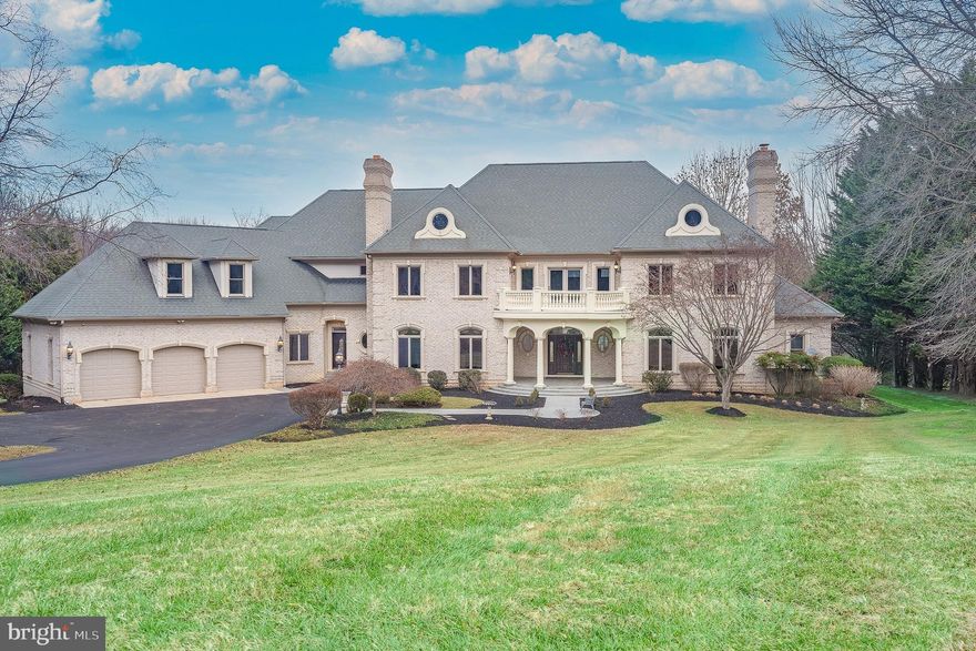 This custom-built brick estate offers exceptional craftsmanship and superior finishes throughout more than 12,000 square feet of living space. Privately situated at the end of a cul-de-sac on a picturesque 3.53-acre lot in the coveted Ridgewood community, the property features a heated in-ground pool and scenic views of a private pond. Inside, ceilings ranging from ten to twenty feet showcase an array of architectural treatments, including tray, vaulted, and barrel designs. The home is richly appointed with five cast stone fireplaces, dual staircases, custom mouldings, window treatments, pillars, and graceful arches. The main level is highlighted by a grand great room, a sun-filled solarium, and a stately library. The primary suite, also located on the main level, features Alabaster light fixtures, dual vanities, a jetted tub, a roll-in ceramic shower, and four walk-in California closets. The fully equipped and expansive kitchen is outfitted with a granite center island, quartz perimeter countertops, Cherry cabinetry, dual sinks, and ceramic flooring, opening to a bright breakfast room with access to the covered porch and slate patios. The upper level offers a wraparound interior promenade connecting five bedrooms, three full baths, an Azek patio, a second laundry room, and a cedar-lined storage room. The walk-out lower level includes a media room, game room, family room, half bath, and substantial unfinished space—well suited for an apartment, in-law or au pair suite.  Hallway walk-in closets are roughed-in and vertically aligned to accommodate a future three-level elevator. Parking is plentiful with a three-car garage and an additional heated, oversized one-car garage with direct access to the basement. The home is serviced by a private well and septic system, five separate oil-fueled HVAC systems, and 600-amp electrical service. Conveniently located near highly rated schools, the property offers easy access to downtown Washington, DC, Baltimore, Annapolis, and Frederick, as well as close proximity to BWI, NSA, NASA, MARC rail, and major transportation routes.