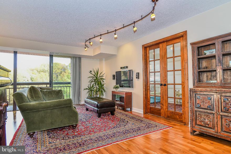 Beautifully renovated end unit with largest floor plan in building. Two bedrooms, two bathrooms PLUS a study! Remodeled kitchen and baths, French doors to study and gleaming hardwoods. Wall mounted TV and surround sound convey. Two balconies on quiet side overlook wooded nature trail. Walk in closets in hall and master. Reserved parking. Metro shuttle, gym, pool, tennis & more. Top rated schools!