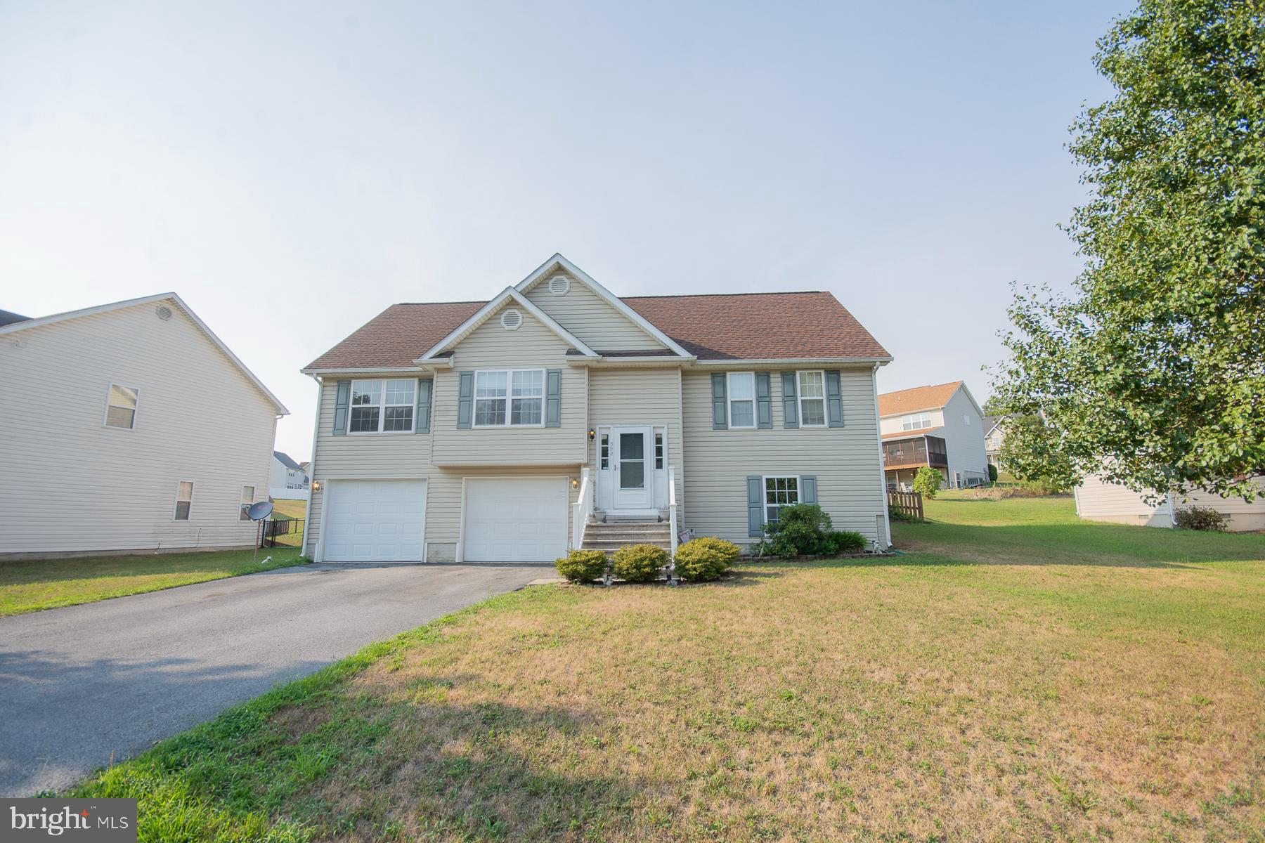 Welcome to your dream home in sought-after Mills Farm! This stunning 4-bedroom, 2-bath split foyer boasts a living room with vaulted ceilings and a cozy gas fireplace, perfect for relaxing. The kitchen/dining combo features recessed lights and sliding doors leading to a large deck and partially fenced backyard, ideal for outdoor entertaining. The primary suite offers a walk-in closet, jacuzzi tub, separate shower, and double vanity. With an additional two bedrooms, a shared hall bath, and a convenient hallway laundry area, this home has it all. The lower level includes a fourth bedroom and a spacious recreation room. Plus, the oversized two-car garage provides ample storage. Conveniently located near I-81, Martinsburg, WV, and Winchester, VA, this home is a commuter’s paradise. Don't miss out!
