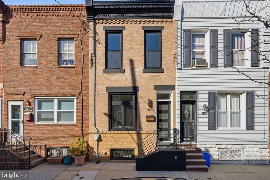 Welcome to 1011 Emily Street, a sleek, new renovation in the heart of East Passyunk with a 10 Year Tax Abatement*. This stunning 2-Bedroom home has a classic brick Philly facade & cornice and boasts a modern design with top-of-the-line finishes throughout. The open concept living area is perfect for entertaining guests, with plenty of space for a dining table and cozy seating area. When you enter the home, you’ll notice the large black windows flood the first floor with natural light, really highlighting the solid oak flooring that flows through the living and dining area up to where it meets the large format tile in the kitchen. The kitchen is a stylish masterpiece outfitted with oak & white slim shaker cabinets and accented with matte brass hardware, a subway tile backsplash, Calacatta quartz countertops and Samsung Bespoke appliances. It’s the perfect combination of style and functionality. Out the full light door in the kitchen is a large, private, rear yard to transform into your urban oasis. Up the custom oak floating staircase you will find 2 generously sized bedrooms and a luxurious 4-piece bathroom with large format gray tiled, a freestanding soaking tub and a frames glass door shower. Downstairs is a fully finished basement for extra living/work/play space that also has a laundry room in the rear, complete with a washer and dryer. 1011 Emily St is located in a Walker’s Paradise and just steps away from East Passyunk Avenue and some of the neighborhoods best amenities including the BOK Building, Artisan Boulanger Patissier, Rival Bros. Coffee, Fountain Porter, River Twice, Palizzi Social Club, El Chingon and the list goes on. Also, only blocks away from the subway and public transportation. Leave your car parked or ditch it because you’ll be within walking distance of anything you could possibly need.