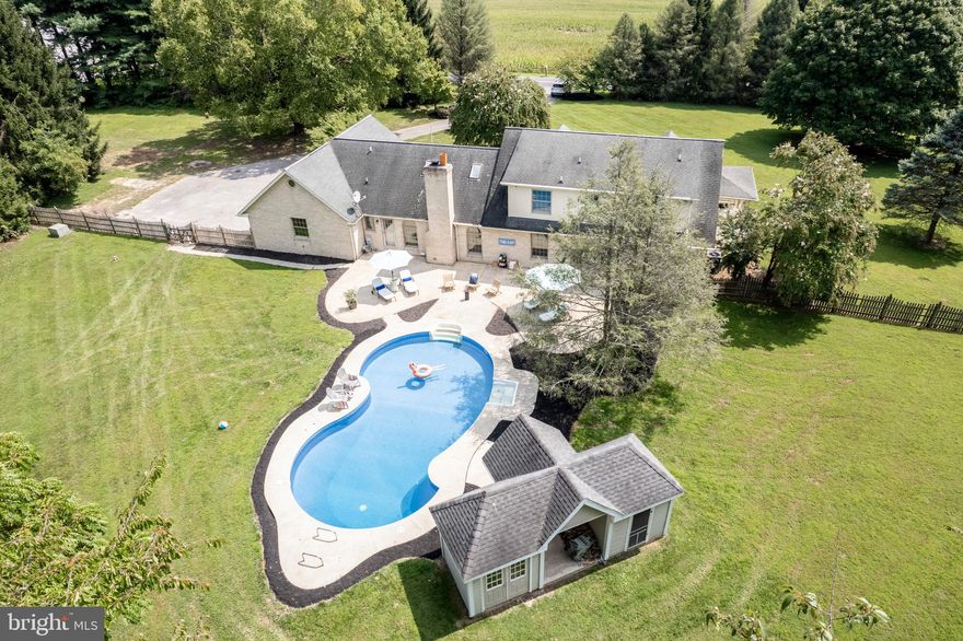 Welcome to your dream home, nestled on 3.5 acres of serene privacy in the heart of Hampstead, Maryland. This luxury property is a true oasis, featuring a stunning pool that creates a tranquil retreat in your own backyard. The home boasts 4 spacious bedrooms and 4.5 baths, including a main-level primary suite with direct access to the pool area, and a secondary primary suite on the upper level, perfect for guests. Step inside from the expansive covered front porch, leading to a foyer flanked by formal dining and living rooms, ideal for entertaining. The interior showcases rich hardwood flooring and a neutral color palette throughout, providing a warm and inviting atmosphere. The heart of the home is the upgraded kitchen, featuring gleaming granite countertops, a large center island, a breakfast area, top-of-the-line appliances, and stylish pendant lighting. Adjacent to the kitchen, the family room offers a cozy space to relax, with a vaulted ceiling and a stunning stone fireplace. The main-level primary suite is a private sanctuary, complete with two generous owner's closets and an attached bath featuring double sink vanities, a corner soaking tub, and a separate shower. The upper-level primary suite is equally impressive, offering a spacious bath for ultimate comfort. The fully finished basement is an entertainer's paradise, with a wet bar and island overlooking a billiards area and family room, along with a full bath. A separate flex space provides room for an exercise area, storage, and more. Additional large workshop is also present on this level. Step outside to your peaceful oasis, where the patio overlooks the rear yard and pool, recently updated with a brand-new liner and new pump. The pool area is perfect for hosting summer gatherings, complete with a pool storage shed and a serene, wooded view that enhances the sense of tranquility. Attached side loading, 3-car garage equips you with plenty of additional storage. This prime location in Hampstead offers both luxury and privacy, with numerous upgrades that cater to a sophisticated lifestyle. Make this exquisite property your forever home.