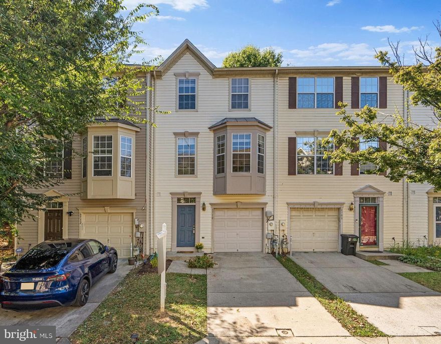 This charming townhouse residence offers 1,772 square feet, 3 bedrooms, 2 full baths, 1 half bath, and a 1-car garage in the sought-after community of The Sanctuary. The fully finished walkout entry level welcomes you with a foyer,  providing garage access and a powder room. A spacious recreation room on this level is ideal for an additional lounge or media space and includes access to the backyard, laundry facilities, and extra storage. The open-concept main level is designed for both comfort and entertaining, featuring gleaming floors throughout. The family room is anchored by a cozy fireplace, while the dining area is enhanced by a chandelier and sliding glass doors that open to the deck. The kitchen is stylish and functional, offering a breakfast bar, stainless steel appliances, crisp white cabinetry, generous counter-space, and a pass-through window with views of the bright and spacious living room. Here, plush carpet and sunlit bay windows create a warm and inviting atmosphere. Upstairs, carpet continues throughout the hallway and bedrooms. A convenient hallway cabinet and counter provide additional storage. The upper level hosts three bedrooms, including the expansive primary suite with a soaring vaulted ceiling, a walk-in closet, and a private bath featuring a dual-sink vanity. A second full bathroom is conveniently located in the hallway to serve the other bedrooms. Outdoor living is equally enjoyable, with a deck perfect for dining al fresco. The backyard backs to a peaceful, tree-lined area, creating a tranquil setting.