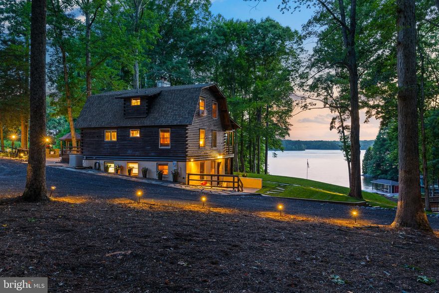Welcome to Camp Wheeler, where serenity meets waterfront charm on the shores of Lake Anna, Virginia.  This picturesque log home retreat is located on the public side of the lake, and offers a tranquil escape from the hustle and bustle of everyday life - with no HOA!  You'll feel like you’re a world away, and everyone in the family will be entertained from the moment you arrive.  Recently renovated and comes fully furnished, this turn-key oasis offers 4 bedrooms, 3 bathrooms, and takes lakeside living to a whole new level.  Whether you're lounging by the wood burning stove in the family room, under the vaulted exposed-beam ceilings, or preparing meals in the spacious kitchen, every corner reflects rustic charm, modern comforts, warmth, and style.  Upstairs in the loft, you'll enjoy the private primary ensuite that also showcases vaulted and beamed ceilings and a walk-in tile shower.  Finished walkout basement offers even more space, with its own living room, another bedroom, full bath and laundry/utility room.  Nestled on 3.79 acres with 215 feet of bulkheaded shoreline, this property includes a private sandy beach, a deep water covered boathouse with composite maintenance-free decking (18 feet deep water at end of boathouse!), a sun deck, electric boat lift, storage room, and a convenient outdoor shower.  Cross over the wooden bridge and climb the ladder inside the charming treehouse; kick back on the daybed, stay cool under the A/C unit, and doze off in an afternoon nap.  Entertaining will be a breeze on the massive patio that is perfect for grilling and dining, gather around the lakeside fire pit to roast s'mores, play a game of corn hole and horse shoes, or unwind on the covered front porch to absorb stunning views of the lake, perfect for enjoying the beautiful western sunsets.  Your landscaping is nurtured by a lake-fed irrigation system, and showcased by landscape lighting at night.  NEW ROOF in 2024 and house stained in 2024!  Don't miss this incredibly rare opportunity to upgrade your life with this waterfront sanctuary, which promises unforgettable moments for the years to come.  Come experience for yourself this truly magical, one-of-a-kind wonderland at Lake Anna.