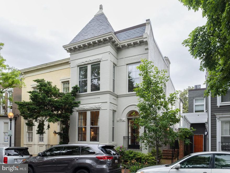 This prime Georgetown property is situated on a beautiful, historic block in the West Village. Just steps away from M Street and close to Wisconsin Avenue, it has easy walking access to all the high-end shops and fine dining the neighborhood has to offer.
 
This bright, semi-detached house is the epitome of a discriminating buyer’s wish list with natural light streaming in from three sides throughout the home, a two-car garage, two-level living, and architectural authenticity. Original floors, high ceilings, and lovely moldings add to the home’s original character while serving as a wonderful setting for contemporary art and furniture. Tasteful renovations and updates have been thoughtfully incorporated throughout the home and include a family room overlooking the beautiful, cultivated garden that surrounds the patio and lines the walkway from the front sidewalk.  
 
The main level opens from a covered side entrance to a generous entry hall, with coat closet, that opens to a large living room with an oversized bay window with window seat, French doors with a Juliet balcony and leaded fantail detail, built-ins, and a ventless gas fireplace with marble detailing. The formal dining room on the right of the front door features elegant details, including a built-in corner cabinet, large window, and a sizeable contemporary chandelier. The gourmet kitchen is equipped with stainless steel appliances, including a six-burner Wolf range, a Ventahood vent, a Sub-Zero French door refrigerator/freezer, a Bosch dishwasher, an Asks dishwasher, and a Beko built-in microwave. It also has granite countertops, and a marble backsplash. The attached family room with powder room is perfect for relaxing and entertaining, with built-ins and two sets of double French doors leading to the private back garden. The garden has a herringbone brick terrace, mature plantings in raised beds including crepe myrtles and dogwood trees, and Rain Bird irrigation and Alliance exterior lighting.
 
Upstairs, the grand primary suite boasts multiple windows with window seats, built-ins, and closets, including a separate walk-in closet. The primary bath features dual vanity sinks, a frameless glass steam shower, and a separate soaking tub. The second bedroom, currently used as an office, has built-in shelves and an en suite half bath. The third bedroom, currently used as a beautifully designed library, has a bank of west-facing windows with a dramatic 96 panes of glass and built-in bookshelves as well as a walk-in closet. The fourth bedroom, on the corner, has built-in bookshelves, and is flooded with light from west and south-facing windows with a full bath next door. A recently renovated lower level adds a guest suite kitchenette with small refrigerator and small freezer, a full bath, a washer/dryer and laundry area with ample storage cabinets and shelves, as well as a room that can become a bedroom. Beyond the garden terrace is a full-sized, two-car garage with additional built-in storage and alley access from 34th and 35th Streets. Next to the garage is a dedicated garbage area with space for six full-sized trash cans for everyday ease separated by a gate from the patio.
 
Nearby Volta Park, with its pool and tennis courts, is a wonderful green space, and the house is conveniently located with easy access to Trader Joe’s, Whole Foods, and a Safeway grocery store. The Key Bridge, Georgetown University, and both Reagan National and Dulles International Airports are easy to get to as well.