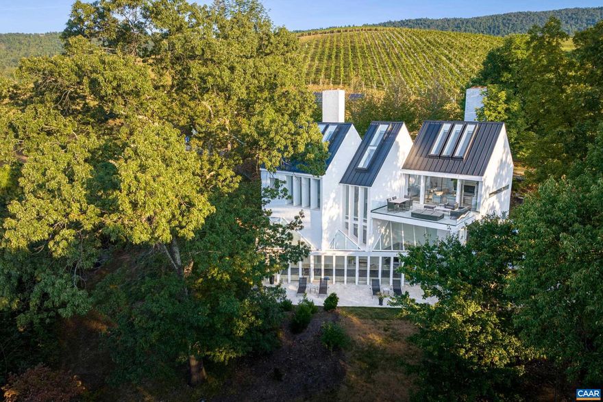 A masterfully crafted home nestled in the Blue Ridge Mountains designed and furnished by award winning architect Hugh Newell Jacobsen. Commanding vistas of the Blue Ridge and Vineyards are highlighted by the clean, stark design. Bright and meticulous interior features vaulted ceilings, large skylights and windows with electric blinds, and glass doors that saturate the home with natural light and incorporate the views as art. The upper level highlights the bright galley kitchen, spacious dining room, living room with travertine fireplace overlooking the outdoor patio, concealed storage and beverage bar. Mid level hosts the primary suite, guest room, and live study/library. Lower level unveils the studio, complete bath, indoor temp controlled lap pool with large windows opening to the rear patio and outdoor kitchen for continuity from inside to outside. A true entertainment paradise. Adjacent to top rated Veritas Winery. Less than 30 minutes from The University of Virginia. The Architect, Hugh Newell Jacobsen, is noted for designing Jacqueline Kennedy's home in Martha's Vineyard, U.S. Embassy in Paris, two museums for the Smithsonian, the Renwick Gallery, Arts & Industries building and addition to the U.S. Capitol, and much more.,Fireplace in Living Room,Fireplace in Master Bedroom,Fireplace in Study/Library