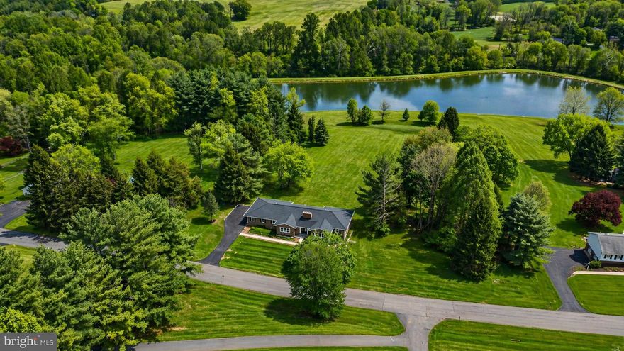 Beautifully renovated 5-bedroom, 3.5-bath rancher set on approximately 2.11 acres with scenic lake views. Offering over 2,400 above-grade square feet plus a finished lower level, this home features bright, open living spaces, updated finishes, and a flexible two-level layout.

The main level offers an inviting living area with fireplace, recessed lighting, wood flooring, and large windows that frame the surrounding views. The dining area flows into a renovated kitchen with a large center island, updated countertops, stainless steel appliances, abundant cabinetry, and modern lighting.

The main level includes three bedrooms, two full baths, one half bath, and laundry. The primary suite features a spacious layout and updated bath with double vanity and walk-in shower.

The finished lower level provides additional living space with two bedrooms, a full bath, open recreation area, and wet bar, offering flexibility for guests, work, hobbies, or entertaining.

Exterior highlights include a rear deck, expansive yard, long driveway, lake views, and attached 2-car rear-entry garage. A beautifully updated Mount Airy rancher offering space, style, and a scenic setting.