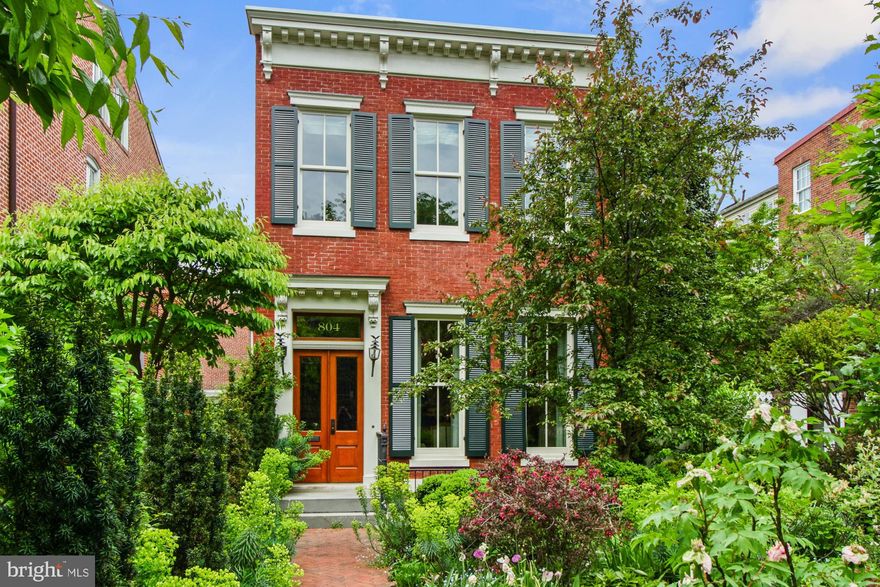 Introducing a rare find detached Capitol Hill home on a double lot near the US Capitol and Lincoln Park.  Built in 1900 , this distinctive Federal style home embodies all the charm and elegance of a bygone era.  The property features both an ample enclosed private East Garden and a more public South Garden which has been written about in numerous publications and is recommended as the starting point on the Capitol Hill Walking Tour.  804 East Capitol St NE features many trademark turn of the 20th century details, including the original cornice above the federal styled façade, new double hung 4 panel divided light windows, ornate interior custom moldings throughout the main living area, and beautiful wide plank heart pine floors.  With custom millwork, and over $1,400,000  in collaborative restoration over a 10 year period to fully restore and this graciously maintained home.  The dramatic entry way, with its beautifully restored staircase, greets guests as they step into a stately double parlor with two wood burning fireplaces, two exquisite, antiqued brass chandeliers and South and East elevation windows.  A French door leads to the East Garden. The Main Entry Hall holds a beautiful well situated powder room with marble floors and wainscoting and leads to the Formal Dining room adorned with crown molding, chair rail, two backlit built-in display cases and a spectacular view of the East Garden. The Cook’s Kitchen features beveled bull nosed Carrara marble counters and Belgian Bluestone floor; Wolf, Miele and Sub-zero stainless-steel appliances with natural gas cooking; a raised Carrara marble breakfast bar with seating; custom solid fruitwood cabinets built to the ceiling with lit upper display areas, a pair of corner Lazy Susan's and wicker basket drawer for more than ample space for the chef in you. If more space is needed for caterers and/or guests, this home also features a 2nd fully equipped kitchen on the lower level.  The 11’ x 8’ breakfast room adjacent to the Kitchen is surrounded by north, east and south elevation insulated windows overlooking the spectacular East Garden and patio entertainment area.  The Family Room features a French Périgord style raised limestone fireplace (steel reinforced bench) reminiscent of typical homes found in the Dordogne River region in the South of France and double, fully operable French doors leading to a flagstone patio and firepit area with a pergola to the left and the East Garden to the right.  The 2nd level has 3 generously sized bedrooms including a primary bedroom with wood burning fireplace, in-suite bathroom and dressing room overlooking the East Garden.  The access to the lower level access is centrally located off the main hall through an almost hidden custom millwork door to a surprisingly naturally lite staircase with exposed brick west wall.  As you descend to the lower level the amount of natural light from two large southern exposure windows will delight your visual senses as it reflects off the light limestone tiled floor of the media room complete with a built-in surround sound system and large flat screen TV (that conveys) for an immersive movie watching experience and an Au Pair suite. The English style South Garden in front of this home is framed by an ornate original wrought iron fence and gates.  Lastly a single car detached garage with over car storage and 2-car parking pad flanks the north end of the lot in the rear alley. All of this and more in short walking proximity to the US Capitol, the Library of Congress, Eastern Market, Folger Shakespeare Library and Theater, Union Station and Lincoln Park. Convenient to some of DC’s and the country’s best restaurants (8th Street SE, Barrack’s Row, the Navy Yard and Penn Ave corridors), grocery stores (Whole Foods, Harris Teeter and Trader Joes) coffee shops, bike and nature trails, gyms and Eastern Market Metro with a 91-walk score.  Check the seller disclosures for a list of upgrades!