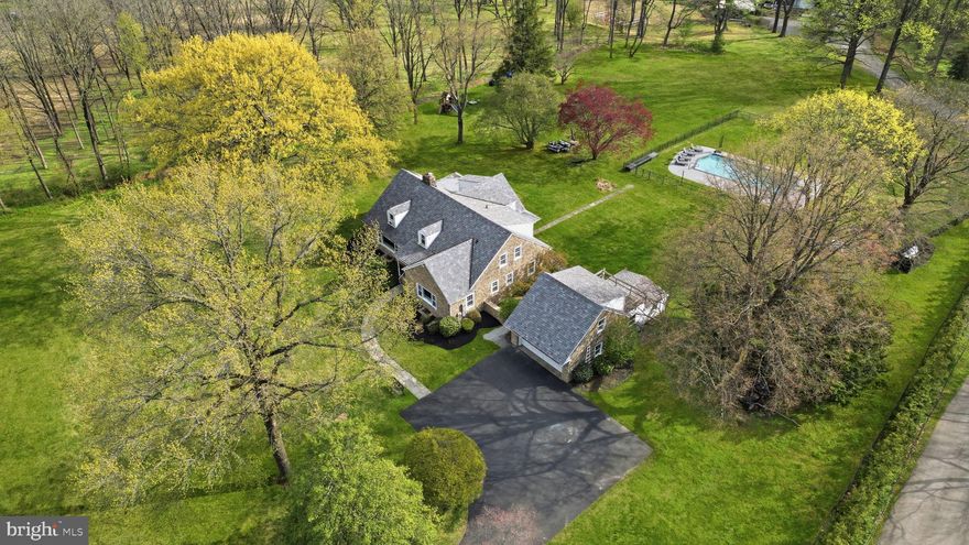 Welcome to Huntingdon Valley — a charming stone Cape Cod set on nearly 3 acres with breathtaking views. This custom-built home offers approximately 4,000 sq ft of living space and is ideally located near Lorimer Park and the Pennypack Trail. Set back from the road down a long private driveway, the property features 5 bedrooms and 3 full bathrooms. The main level opens with a grand foyer showcasing hardwood floors and a statement chandelier. The formal living room is filled with natural light from oversized picture windows and features a full stone fireplace, exposed beam ceiling, recessed lighting, custom built-ins, and French doors leading to the side yard. The formal dining room offers elegant built-in servers with marble tops, crown molding, and access to a bright sunroom with stone flooring, wood and stone accents, and access to the rear patio. The kitchen includes a large island with granite countertops, stainless steel appliances, and a breakfast area overlooking the expansive backyard. Also on the main level is the primary suite with ample closet space and private bath, along with a second bedroom and full hall bath. The second floor includes two generously sized bedrooms, a full bath, a large walk-in attic, and a versatile fifth suite with vaulted ceilings—perfect for a playroom, office, or gym. Step outside to your private retreat featuring a brand new, fully updated in-ground swimming pool, surrounded by ample patio space—perfect for entertaining and enjoying the peaceful setting. Additional features include a detached 2-car stone garage with ground-level storage, a second-floor space with balcony potential, and architectural details such as hardwood floors, crown molding, chair rail, paneled doors, and exposed beams. Recent upgrades include newer windows, newer granite countertops, Upgraded Well System, Newer HVAC and hot water heater, with over $190,000 in improvements. Possible subdivision or addition of outbuilding makes possibilities endless for developer, contractor! Don’t miss this opportunity before it’s gone!