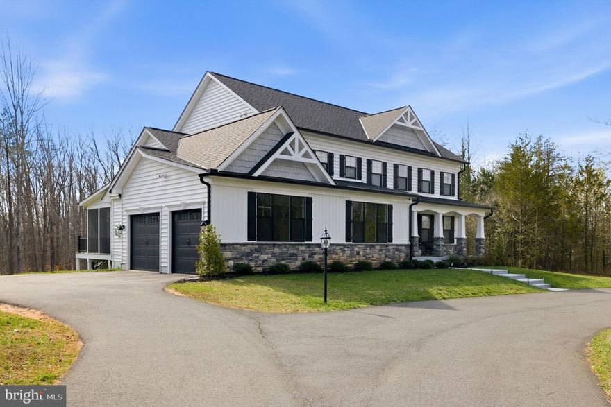 Built in 2023 and presenting like new, this stunning Sullivan Reserve home offers over 4,600 square feet of thoughtfully designed living space on a private 3.55-acre corner lot with a 300-foot circular driveway and classic lamp post. Featuring 5 legal bedrooms and 3.5 baths, the home includes 3,218 square feet above grade plus a 1,394 square foot finished basement, along with an oversized 4-car tandem garage with epoxy flooring. Inside, all three levels boast 9-foot ceilings and engineered hardwood flooring throughout, creating a seamless and elevated feel. The main living area is anchored by a beautifully upgraded kitchen with an oversized picture window, quartz surfaces, wine bar, and coffee bar nook, complemented by custom staircase railings and modern lighting fixtures throughout. The primary suite offers a true retreat with vaulted ceilings and a spa-inspired bathroom featuring a steam shower with massage functions and body sprays. Outdoor living is exceptional with a fully covered, all-seasons enclosed space featuring barn-style sliding screened doors, an extended deck, and a cascading staircase leading to the expansive, pool-capable yard. Additional features include black exterior windows and gutters along the front elevation, a whole-home water softener treatment system, and well and septic. Ideally located in a private and peaceful setting with convenient access to I-95, Quantico, and shopping, and zoned for top-rated Stafford County schools including Margaret Brent Elementary, Rodney Thompson Middle, and Mountain View High School.
