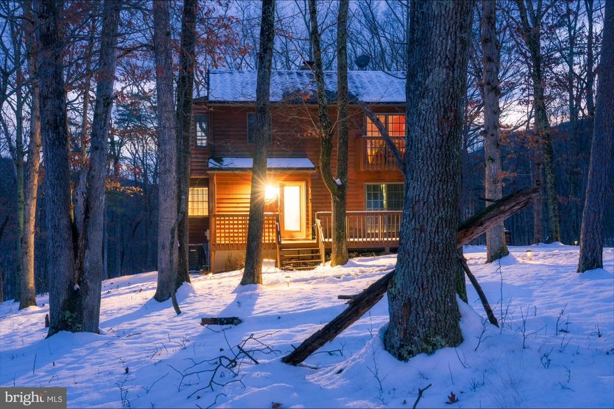 Experience the pinnacle of mountain living at 170 Cardinal Ln in
Berkeley Springs, WV – an exquisite 4-bedroom, 3-bathroom saltbox
cabin that redefines sophistication across its sprawling 2,326 square
feet. This captivating residence beckons you into a haven of rustic
elegance, where every detail is crafted for those who seek the
extraordinary.

Step into the open living area, where a majestic stone fireplace
creates a cozy ambiance, setting the stage for intimate gatherings.
The well-appointed kitchen is a culinary delight, seamlessly
integrated into the open floor plan that connects the living, dining,
and kitchen areas – an ideal space for creating memories with the
family or refined entertaining with friends. Elevate your leisure with
the convenience of your own personal home theater - with an automated
screen and projector, transforming your movie nights into
extraordinary cinematic experiences.

Retreat to the spacious bedrooms, each a sanctuary of peace, including
a master suite on the main level, an upper level with a charming jack
and jill style bath between bedrooms 2 & 3, and a versatile fourth
bedroom/office on the lower level, complete with a full bath and
laundry facilities.

Enjoy the invigorating mountain air while soaking in a steamy hot tub
with the beautiful ambiance of rolling hills. Spend your afternoons
grilling up gourmet dinners or savoring afternoon drinks on the fully
screened porch. This exceptional home stands proudly on a generous
.88-acre lot in the exclusive Coolfont Mountainside community,
positioned on the outer edge and offering unparalleled views into the
mountains and the soothing sounds of a babbling creek. This is a
property that offers the highest levels of peace and quiet for those
who appreciate serenity.

Situated in the highly sought-after Coolfont, you'll enjoy privileged
access to a suite of amenities, including scenic hiking trails, an
inviting community pool, and an environment that serves as a sublime
escape from the relentless pace of everyday life. Culinary delights
await just a short distance away at Coolfont restaurant and the BS
Brew Pub. Not just a home, but also a potential investment
opportunity, Coolfont is renowned as a desirable rental location year
round!

This residence is a meticulously curated masterpiece, ready for your
personal touch. With WiFi-enabled lighting, furniture, and household
items conveying with the home and offering a sense of luxury, this
sanctuary is poised for you to claim as your ultimate retreat.
Conveniently located near downtown Berkeley Springs for indulgent
spas, boutique shopping, and exquisite dining experiences, and just a
few miles from Cacapon State Park – offering a playground of outdoor
pursuits from hiking and boating to swimming and golf – this is much
more than just a residence; it's an embodiment of your refined
lifestyle. Seize the opportunity to make this extraordinary haven your
mountain retreat sanctuary.