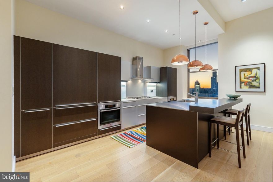 NEW LISTING | Exceptional Modern Masterpiece at The Ayer

Live the life you deserve in this architectural gem at the prestigious Ayer Condominium, perfectly situated on historic Washington Square in Society Hill. This stunning corner residence blends timeless design with exquisite modern upgrades, showcasing soaring 11’7” ceilings, incredible natural light, and wide-plank white oak flooring throughout.

The expansive Great Room offers two distinct seating areas and has a dramatic setting for entertaining, complete with a dining area that accommodates 20+ guests. A newly installed Porro rosewood media wall integrates a Bang & Olufsen audio system, a 77” LG OLED TV, and gallery-style glass-lit display shelves—ideal for art collectors.

The bulthaup-b3 kitchen is a chef’s dream, reimagined with a sleek stainless-steel island, breakfast bar, there is a pretty white marble powder room, Miele and Sub-Zero appliances, and abundant storage—equal parts form and function.

The Primary Suite is a serene retreat with custom closets, new flooring, and a luxurious marble bath featuring an oversized walk-in shower. The second bedroom’s 10:6 ceiling height boasts an en-suite stone bath and a generous closet space. A third flexible room, ideal as an office or guest suite, enjoys natural light and custom-built-ins.

Smart home automation controls lighting, shades, and sound throughout.

Residents enjoy access to 6-star amenities, including:

Hotel-style concierge

Valet parking at your door

Chauffeur-driven hybrid BMW

State-of-the-art fitness center

Common terrace with herb garden

On-site management

One on-site garage parking space with EV charging is included in the sale and covered by condo fees. [SUV spaces are limited]