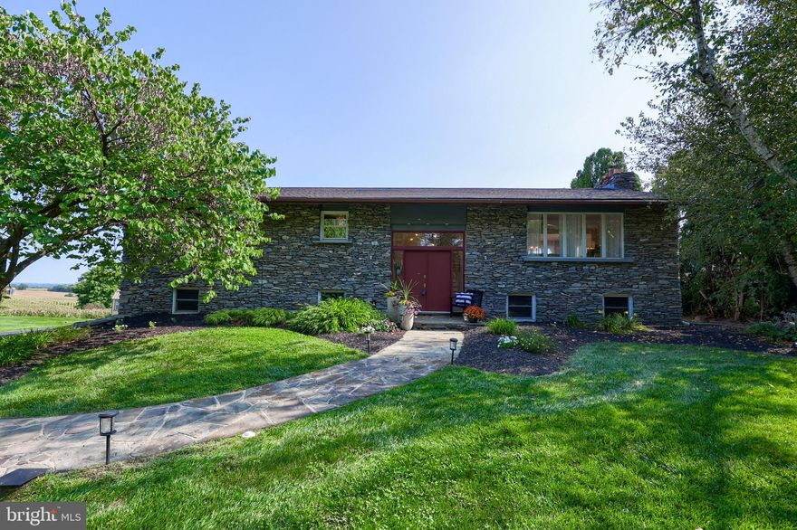 Rare Opportunity Available! Homes like this rarely come on the market, so act now! When you enter the foyer of this mid-century modern home, you immediately notice the spaciousness it offers. Wide open staircases and oversized rooms allow natural light to accent the beautiful floors and custom kitchen cabinetry and appliances. The abundant windows invite nature inside. The bath, with a private entrance to the primary bedroom, offers a relaxing retreat from the day's stresses with a soothing soaking tub. This home is designed to make family gatherings and entertaining a breeze, whether by the inground pool, on the maintenance-free deck overlooking the countryside, or in the massive family room with a stone fireplace and wood-burning insert. The family room also features an extra kitchenette with a range and compact refrigerator. The oversized 28' x 28' side-load garage can accommodate all your toys as well as your cars. The exterior of the home features dry stack stone walls that extend to the front, giving it a timeless look. The electric baseboard heat has not been used since the heat pump was installed. This home will only be available for a short time—make your showing appointment now!
