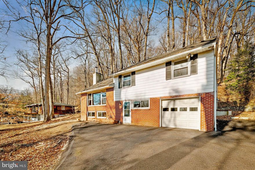 This unique five-level split home sits on over an acre of tranquil, wooded land. Designed to maximize light and space, this residence offers a perfect blend of classic charm and modern convenience, making it an ideal sanctuary for families or anyone seeking comfort in a beautiful setting. Step into the welcoming living room, where a striking wood-burning brick fireplace creates a cozy atmosphere. The large picture window frames scenic views and floods the room with natural sunlight, making it a delightful spot for relaxation or entertaining guests. Adjacent to the living room, the dining area provides direct access to a flagstone patio. This outdoor retreat features a handsome stone retaining wall, offering a charming space for alfresco dining, gatherings, or simply enjoying the peaceful surroundings. The open kitchen is well equipped making meal preparation and clean-up a breeze. Its functional layout is perfect for both everyday living and entertaining. The family room/library impresses with custom built-ins perfect for entertaining.  The lower level features a comfortable den, a laundry area with outdoor access to the yard, a powder room, and direct entry into the attached garage for added convenience. Featuring four spacious bedrooms—two with beautiful hardwood floors and a fourth currently serving as a home theatre—and two and one-half baths.  This residence is part of the award-winning Upper Merion Area School District Perfectly situated, this home offers quick access to the TRAIN, Expressway, PA Turnpike, King of Prussia, Routes 320, 30, 202, and The Blue Route, ensuring commutes and daily errands are a breeze. Experience comfort, convenience, and value in this delightful home—schedule your private showing today!