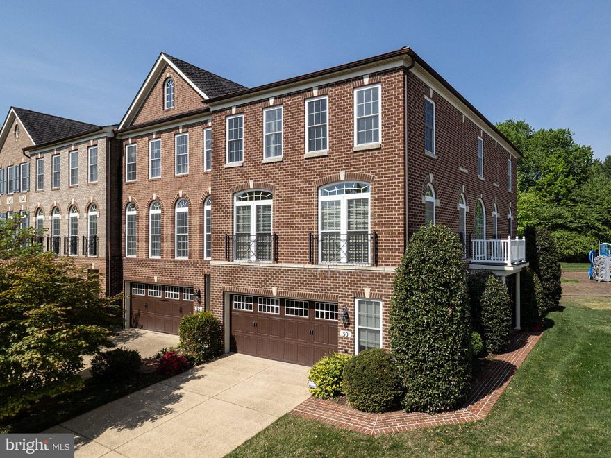 This exquisite brick townhome has nearly 3,000 sq feet of immaculate living space.  The entry level features an expansive recreation area with a fireplace, full bath and oversized two car garage. Reaching the main living area, you are welcomed by sun-drenched living areas with rich hardwood flooring, extensive moldings and architectural columns. The formal living and dining rooms share an open area perfect for grand entertaining. The spacious kitchen shares space with a breakfast area and family room. The kitchen has cool granite countertops, premium hardwood cabinetry and stainless steel appliances. Enjoy serene green space from the back deck which is accessed from the breakfast area. The upper level features three bedrooms, a hall bath and laundry room. The owners’ suite is an oasis with a trey ceiling, oversized walk-in closet, and a sparkling private bath with premium ceramic tile flooring, dual vanities, and spa-like shower. This is a very special home. As an end unit, it has an extra ten large windows that fill every space with natural light making it feel like a luxurious single family home. The location is just a couple minutes away from grocery stores, shops and entertainment at Rio, Crown and Kentlands. The property is currently assigned to Fields Road ES, Ridgeview MS and Quince Orchard HS. Starting the 2027-2028 school year, the assignments are planned to transition to Frost MS and Wootton at Crown HS. See MCPS for detailed information.
