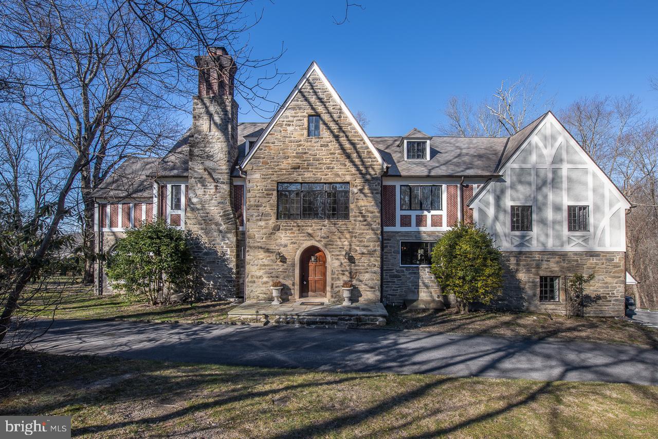 Spectacular, gated, stone, 4955 square foot Tudor manor has been beautifully updated to bring a modern feel to this timeless home. Sitting on an amazing 2.21 acres, this architectural masterpiece has oversized rooms, stunning hardwood floors, 9ft ceilings, and loads of charisma & light. Generous-sized living room with coiffured ceiling, and built-in shelfing around fireplace. Formal dining room with French doors leading to the fabulous brick patio overlooking a tranquil pond, magnificent pool area & level fenced-in park like setting with stunning hardscaping & landscaping. Elegant and charming stone Family room. Remodeled, chef's eat-in Kitchen is sure to impress with top of line stainless steel appliances, and gorgeous new countertops and white cabinetry. From the grand entrance, ascend the open stairs to the spacious main bedroom suite with sitting area, large walk-in closet & new bath with double vanity, glass shower & attractive soaking tub. Three additional oversized bedrooms all with updated ensuites complete this level. 2 car garage, tons of storage, 2-zone HVAC, custom outdoor lighting & sprinkler system, Award winning Lower Merion schools. Close to several shops and restaurants and easy city commute. This home is waiting to tell it’s next story, make it yours!