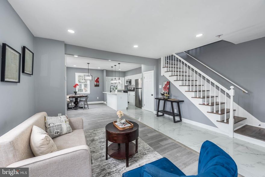 Discover this newly renovated end-of-group rowhome, offering approximately 1,500 sq. ft. of living space designed for modern living. Enjoy an open floor plan with wood flooring throughout, a spacious living room, and a separate dining area perfect for entertaining. The island kitchen boasts stainless steel appliances and Quartz countertops for a stylish and functional cooking space. Upstairs, find 3 bedrooms and 1 full bath, while the finished basement features a family room, additional bedroom, and full bath, ideal for guests or extra living space. Relax in the fenced yard and enjoy the convenience of being close to shopping and restaurants. This home is a must-see!