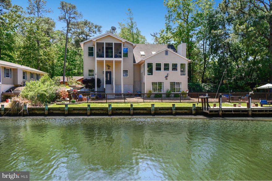 Comfort, privacy, and waterfront living come together in this fully renovated three-level contemporary home, ideally positioned along one of the quietest canals in Ocean Pines with direct access to the bay and beaches of Ocean City. Offering 4 bedrooms, 3.5 baths, and approximately 3,250 square feet, this exceptional residence has been thoughtfully updated to provide the perfect blend of coastal comfort, functionality, and entertaining space.   Designed with an open-concept layout, the home features soaring vaulted ceilings, skylights, and expansive windows that fill the interior with natural light while showcasing tranquil water views from all three levels. Multiple gathering areas throughout the home allow family and guests to comfortably spread out, including a spacious great room, waterfront den, and bar area adjacent to the kitchen.  The middle level also offers a private guest suite with en suite bath for those wishing to avoid stairs, an additional powder room, laundry room, and direct access to the oversized multi-car garage with front and rear access points.   Upstairs, the primary suite serves as a true private retreat, spanning approximately 768 square feet and featuring its own three-season porch overlooking the water. This luxurious space includes a large walk-in closet, natural gas fireplace, and beautifully renovated spa-style bath complete with extensive cabinetry, dual-person Jacuzzi soaking tub, and walk-in wall-jet shower. Two additional bedrooms, two porches, and another full bath complete the upper level.   The ground level offers even more flexibility with two freshly renovated waterfront rooms ideal for entertaining, relaxing after a day on the water, or hosting the perfect crab feast. Walls of windows and sliding glass doors provide panoramic canal views and direct access to one of the largest waterfront backyards in Ocean Pines. The oversized .35-acre lot includes a full-length fenced yard, expansive private bulkhead, maintenance-free dock with fish cleaning station, hardscape walkways, and ample room for kayaking, crabbing, pets, and outdoor gatherings.  Extensive 2026 renovations include a full interior repaint, all new luxury vinyl plank flooring, carpet, and ceramic tile throughout, remodeled kitchen and baths, a fully renovated third level with dedicated mini-split HVAC system, updated plumbing and lighting fixtures, new vanities with quartz and marble countertops, updated toilets, ceiling fans, and more. Additional highlights include three-zone heating and cooling, instant hot water system, air purification system, dehumidification system, fire and alarm monitoring with cameras, oversized garage with 9-foot door for possible boat storage, and parking accommodations for up to 6+ vehicles.   The home also offers a full concrete crawlspace with convenient interior access to mechanical systems including the furnace, plumbing, dehumidifier, air purification equipment, and AirBoss controls. Pride of ownership is evident throughout, with the roof and multi-zone HVAC systems regularly cleaned and professionally serviced.   Move-in ready and meticulously maintained, this rare waterfront offering combines peaceful coastal living with convenient access to the bay, ocean, dining, marinas, and entertainment of the greater Ocean City area.