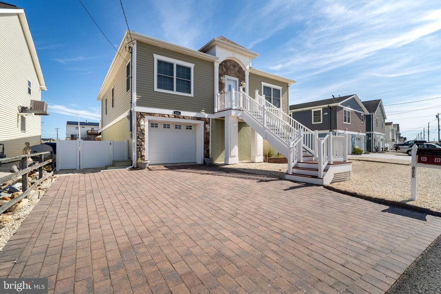 Waterfront Living at the Jersey Shore! Discover the perfect blend of comfort and coastal charm in this beautifully raised ranch, built in 2014 and nestled along a serene lagoon. Offering 3 spacious bedrooms, 2 full baths. This home is designed for relaxed waterfront living. Open-concept kitchen- dining and living area, granite counter tops, ceramic tiled backsplash, SS appliances, peninsula breakfast nook, ceramic tiled and hardwood flooring. Sliding glass doors leading to a spacious rear composite deck enjoy sitting under the retractable awning overlooking the water. Paver driveway and rear patio. Enjoy sipping away on your favorite drink at your own "Tiki Hut". Private dock with ramp and floating platform- ideal for boating, fishing, swimming, crabbing and all your water toys. Oversized two-car garage one garage door with ample storage. Convenient outdoor hot & cold shower for rinsing off after your saltwater adventures. Your own amenities, your own lifestyle and freedom. Whether you're chasing sunsets, docking your boat, or hosting summer cookouts, this home is your getaway to the salt life lifestyle-laid back, luxurious, and all yours. Move in ready. Start living the dream. Only 30 minutes to AC and LBI for added entertainment, excitement and fun.