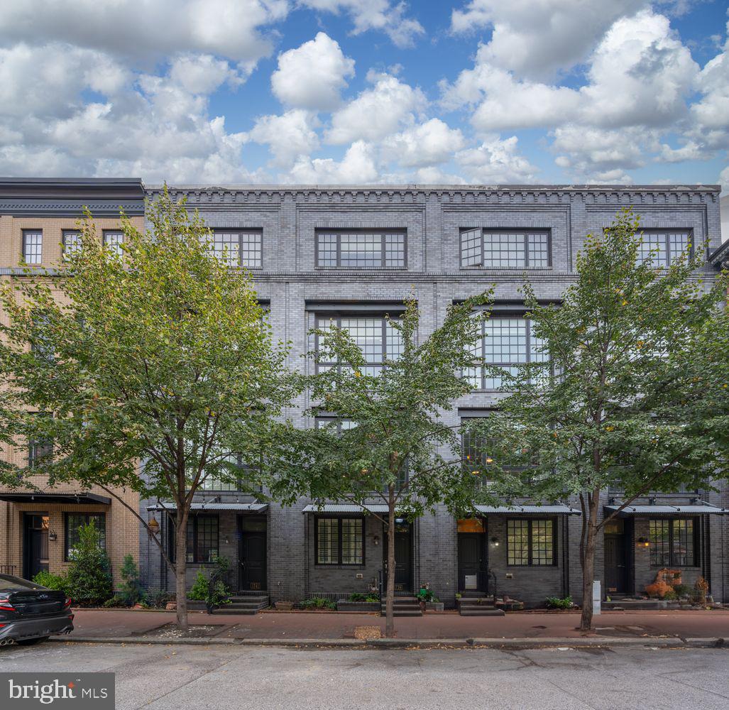 Discover the best of Fells Point in this rare Merchant Point residence—an urban sanctuary offering quiet enjoyment just steps from the waterfront. Built in 2012, this home is among the newest in Historic Fells Point, combining contemporary design and soaring ceilings with the character of one of Baltimore’s most storied neighborhoods.
The entry level provides a two-car tandem garage with ample storage, a powder room, and a flexible office space—ideal for today’s work-from-anywhere lifestyle. On the main level, natural light pours through floor-to-ceiling windows, framing a dramatic steel staircase and open living area. The chef’s kitchen features Caesarstone counters, induction cooking, a massive island, and an oversized wine fridge, seamlessly connecting to a private balcony—perfect for morning coffee, grilling, or a quiet evening retreat.
Upstairs, the primary suite includes a spa-inspired bath with soaking tub and walk-in shower, plus a generous closet. A second bedroom and full bath complete this level.
The top floor is a true highlight: a spacious family room opening to dual rooftop decks with sweeping city skylines, direct water views, and the iconic Pendry Hotel. A third bedroom—currently designed as a theater room—offers flexibility to serve as a guest suite, home office, or creative retreat. Whether hosting friends on the decks or enjoying movie night inside, this level was built for connection and lifestyle.
Smart-home upgrades, refreshed finishes, and new garage flooring enhance the home’s modern feel, ensuring a turnkey experience for discerning buyers.
All of Fells Point is at your doorstep—boutique shopping, Pitango Bakery, Sacre Sucré, Greedy Reads, Pilates House, neighborhood coffee shops, and the city’s best dining—all without being in the thick of the late-night energy. Just two blocks to the waterfront, this residence blends neighborhood vibrancy with private retreat, all in the comfort of a newer build.