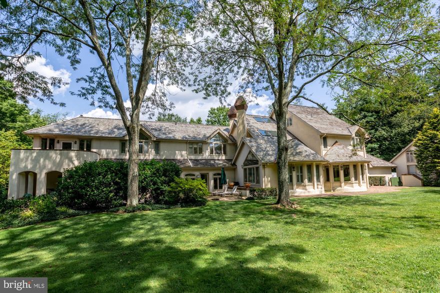 Sprawling contemporary Mediterranean-style beauty on 2.5 private, lush acres with golf course views and perfect positioning across from the Philadelphia Country Club s 8th hole! Enjoy refined luxury living at its best amidst beautiful natural surroundings, graced by an exquisite 5 bedroom 5.1 bath main residence and adjacent 1 bedroom 1 bath cottage for your guests. The striking stucco estate boasts distinctive architectural details and outstanding curb appeal, met by generous outdoor patios and a seamless flow for summer entertaining. Ample driveway parking, an attached 2-car garage with oversized cabinetry and epoxy-finished floors, plus an additional 3-car garage provide lots of space for vehicles.Light, air, and luxury living unfold in the grand foyer enveloped by windows, with a lovely siting nook at left and gorgeous inset granite floors. The formal living room at right is soaring and magnificent, with vaulted ceilings, windows galore, and a charming gas log fireplace for cozy winter nights. Enhancing the sophisticated ambience, and perfect for hosting gatherings large or small, is an elegant music room; regal dining room with a wood-burning fireplace, wet bar, custom cabinetry & wall of windows; rich wood-paneled library with custom bookshelves, screening & office areas; and 2-story family room drenched in light with a gas fireplace, custom built-ins & window seats.Culinary creations are inspired in the superlative Bulthaup kitchen, appointed for the chef featuring honey-toned cabinetry, brushed stainless accents, black granite countertops, 2 large under-counter sinks, state-of-the-art Sub-Zero, Viking & Gaggenau appliances, a built-in ice maker & Miele coffee center. Adjacent is a fully-equipped catering kitchen, laundry room, powder room & mudroom/family entrance with garage access. Upstairs is an oasis all its own, with a huge, divine master suite boasting his & her baths, phenomenal closets & custom storage, a sunny gym & outdoor deck with hot tub for unwinding in nature. The comfort continues with 3 more spacious BRs (one en-suite) and a shared full bath. The 3rd story suite has a full bath & abundant closets. Every whim is satisfied on the finished lower level, a haven with a screening room, game room, crafts room, full bath with sauna + plenty of storage. The detached guesthouse is also a retreat with a vaulted living room, full kitchen, en-suite bedroom & private deck. In prime Lower Merion Twp near top schools, all amenities & convenient transportation!