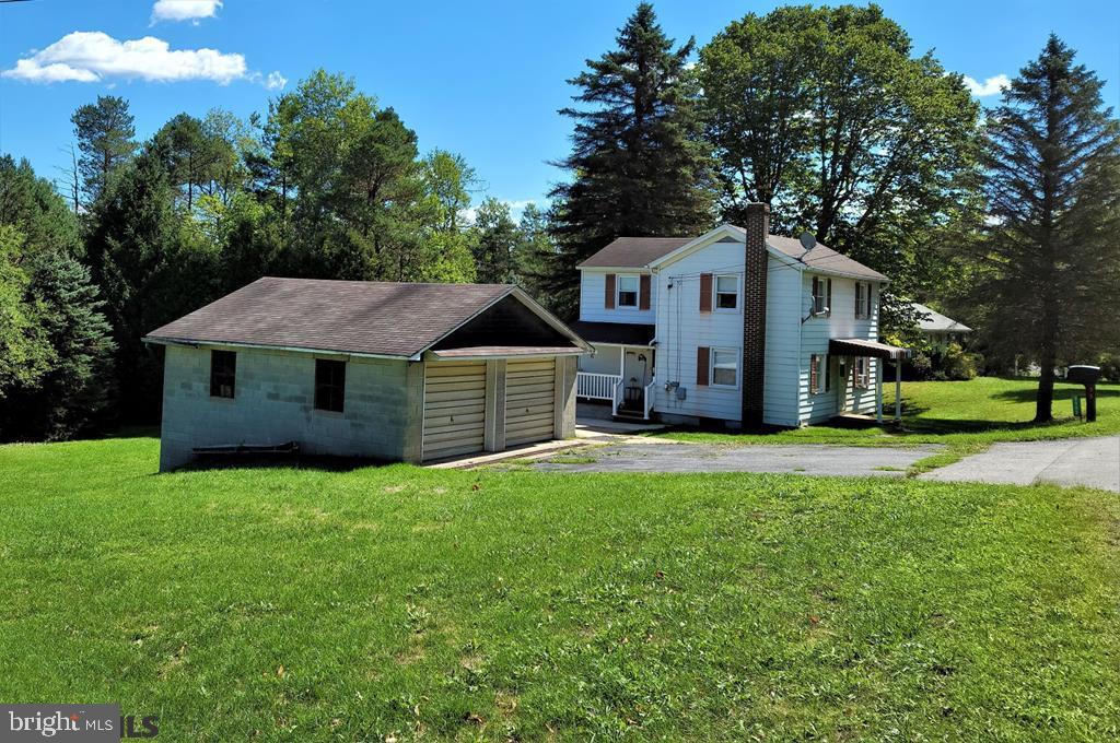 This quaint two story, three-bedroom home sits front on .74 Acres making for a large back yard. Your vehicles will be kept out of the weather in the detached 2 car garage with additional storage area underneath. Covered side porch entrance leads into the eat in kitchen. To the left a full bath and laundry room equipped with a washer and dryer. Forward of the kitchen a generously proportioned living room, large enough to include a dining area if you wish. Carpeted stairway leads up to three bedrooms, main bedroom boasts its own powder room. Unfinished basement with walk out has an additional shower stall and toilet. Great home awaiting your personal touch. Contact Ryen Realty now and set up a showing.