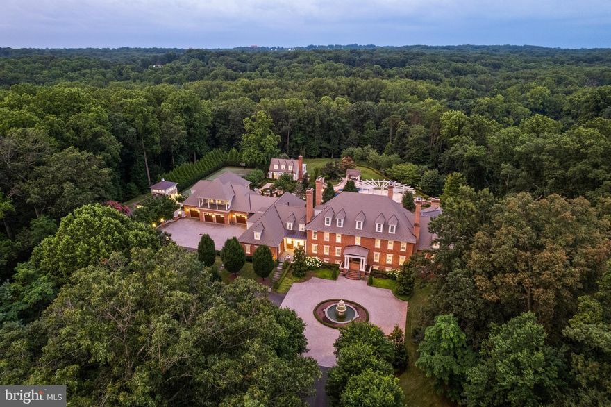 Welcome to Edgehill Estate—an extraordinary residence that embodies timeless elegance and modern luxury in the heart of Oakton. Set on 11 beautifully landscaped acres, this stately, oversize brick and stone colonial—inspired by the historic Carter’s Grove—offers over 20,000 square feet of meticulously designed living space. This grand residence masterfully blends classic American Colonial design with the highest level of modern luxury, technology, and artisan detail. 

Every inch reflects unparalleled craftsmanship—from hand-carved Chesney mantels imported from London to walls hand-painted by famed Hollywood designer Harold Grieve. A formal foyer sets the tone with coffered ceilings, a foot of crown molding, custom millwork, plaster medallions, mahogany inlays, and antique wall sconces, guiding you into the heart of the home. 

The Primary Suite is a wing of its own, featuring dual dressing rooms, a sitting room with coffee bar, a spa-inspired marble bath with a steam shower, a fireplace, and balcony access overlooking the grounds. Designed for both everyday comfort and extraordinary entertaining, the estate includes a chef’s kitchen with Thermador appliances; multiple living rooms, a library, a home gym, a steam room, a sauna, a jetted hot tub spa room, and access to one of the largest residential pools in Fairfax County with grotto waterfall, fire bowls, infitity edge, and slide.

The resort-style grounds offer travertine throughout, pergolas, an alfresco outdoor kitchen, a tennis court, multiple fire features, and a three-tiered fountain, surrounded by lush landscaping that blooms year-round. A 13-car garage complex, guest house, elevators, and commercial-grade generator ensure the highest level of comfort, privacy, and preparedness.

Edgehill Estate is more than a home—it’s a legacy property offering an unmatched lifestyle of privacy, prestige, and timeless beauty.