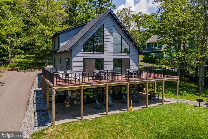 Beautiful modern lake-access home with five bedrooms, four baths, and a bright open layout built for easy mountain living. Finished in 2022, the home feels fresh, clean, and dialed-in from the start. The wrap-around Trex deck sets the tone with plenty of space to gather. The kitchen is sleek and modern with simple, streamlined finishes. Vaulted white-shiplap ceilings lift the great room with light. Two stone fireplaces anchor both the main level and the lower game room, with a wet bar that keeps everything close and convenient. The walk-out level opens to a covered stamped-concrete patio for extra room to spread out. Covered hot tub sits just off the main patio, with a built-in fire pit for lounging under the stars. Located in Stillwater, just minutes from Dutch’s at Silver Tree and Wisp Resort. Private community lake access that feels calm and tucked away. An established rental, “Lake Daze” is being sold turn-key, fully furnished. Don’t miss your chance to own a shiny new chalet, that offers easy access to all four seasons. Call today for details!