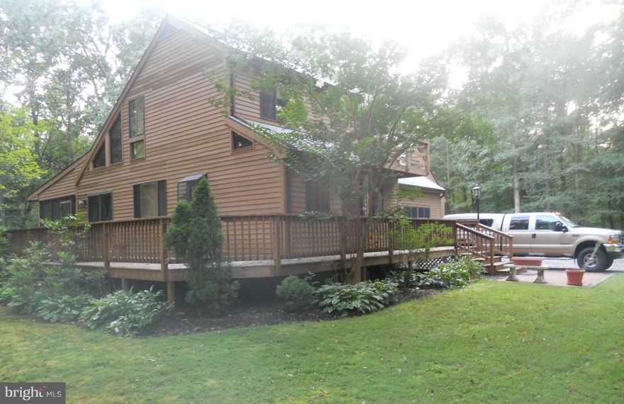 Wooded paradise on 10+ acres, secluded, fenced and gated.  Enhanced with a well maintained 3 BR 2 BA contemporary and a 2 car attached garage.  But that's not all - large screened in porch overlooking the back yard and equipped with a hot-tub for your relaxation.  Enjoy wildlife and watch the color of the seasons change in your  own private park.  Cozy wood stove means low heating costs.