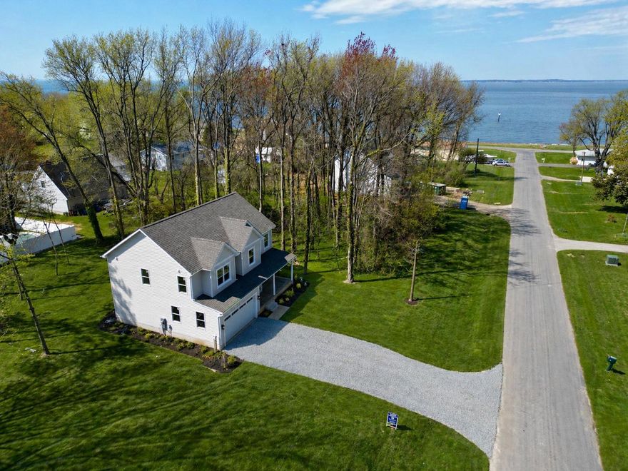 Brand new completed 2-story home offering 4 bedrooms, 2.5 baths, and glimpses of the Chesapeake Bay right down the street, NO HOA! This thoughtfully designed home features a spacious open layout highlighted by a large kitchen island with quartz countertops, full quartz backsplash, and stainless steel appliances—perfect for everyday living and entertaining.
The primary suite includes a beautifully finished 3-piece shower with quartz surrounds and a quartz vanity, while all bathrooms are upgraded with quartz tops and quality finishes. Throughout the home, you’ll find upgraded interior trim work, along with dovetail cabinetry featuring soft-close drawers and doors for a high-end feel.
Exterior upgrades include enhanced siding details, a welcoming front porch with brick rowlock accents, and a rear composite deck with rails and steps leading to grade—ideal for relaxing or hosting. The conditioned crawl space is built right with drain tile, rat slab, and spray foam insulation for added efficiency and peace of mind.
Driveway completion is scheduled for next week—don’t wait to make this home yours! Enjoy a great street perfect for evening strolls, with easy access to the Chesapeake Bay just a short walk away.