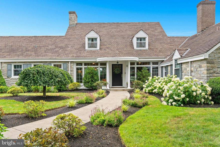 At the end of a quiet country drive lies 7.9 acres of rolling green lawns and tall trees, embracing a stone manor home in a setting of lush greenery. Long admired by afar and cherished by those invited in, this notable residence is minutes from Cedar Crest Boulevard, Lehigh Country Club,  Lehigh Valley Hospital and I-78.  
Inspired by the beauty of its surroundings, the home has a recently renovated and reimagined interior that merges past and present. At the center is the renovated kitchen topped with quartz counters, island seating, coffee bar, high-end appliances, spacious walk-in pantry, and wall of windows. The kitchen flows into the dining room with a serving buffet/wet bar and beverage center. A generously-sized living room enjoys the same wide plank random width white oak flooring and pastoral views, while the family room features a unique barrel ceiling and walls of windows and doors. An advantageous first floor primary suite has abundant closet space and private bath. Upstairs bedrooms are large, with two renovated bathrooms, walk-in cedar closet, and easily accessible storage room. A remodeled flex/exercise/play room, laundry, mudroom, and heated garaging for 5 cars are well-designed and convenient.
Flagstone patios, a covered porch, picturesque gazebo and shady sitting areas invite elegant outdoor dining and entertaining, with a serene fish pond and waterfall nearby. Enjoy seclusion without isolation and plenty of room for backyard sports and quiet walks all in a coveted location.