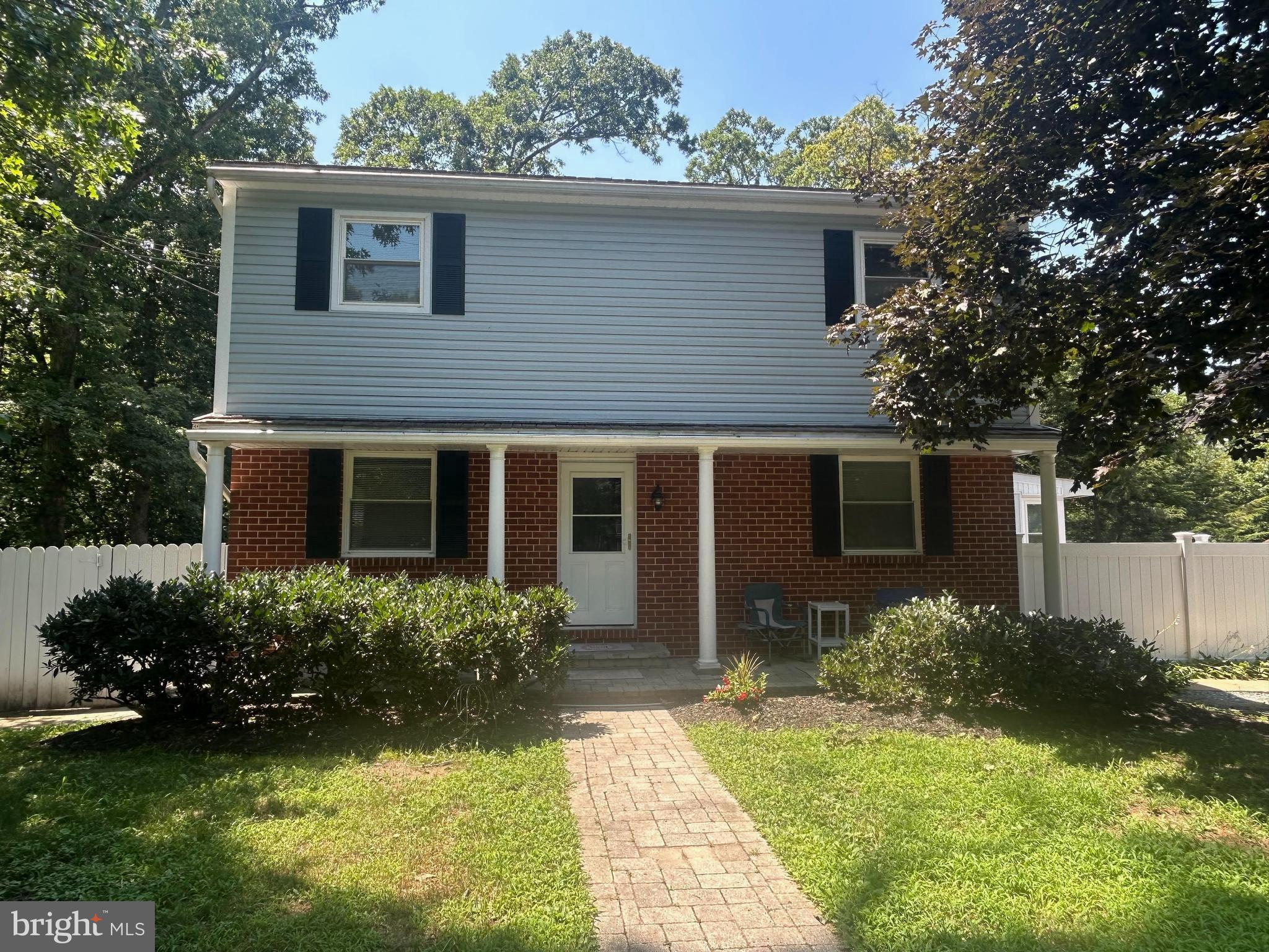PRICE REDUCTION!! Please see below remarks for correct high school info. This expansive three-level colonial, originally built in the 1960s, blends classic character with modern enhancements. Thoughtful additions and updates throughout the years have expanded the home’s space and functionality, making it ideal for multi-generational living with a full in-law suite in lower level. It is ideally situated on .43 of an acre lot backing to woods, bordering a small stream. The main level features original hardwood flooring in the entryway and dining room. The generously sized kitchen is perfectly designed for both everyday living and large gatherings with ease, and boasts two wall ovens and refrigerators, along with a convenient laundry closet. Just off the kitchen is a 12x17 sunroom, along with a breezeway leading to a composite deck complete with hot tub and ramp for easy access. The spacious living room features a wood stove insert with brick hearth. For those seeking single level accessibility, there’s a main level bedroom and full bath with shower, providing comfort and privacy without the need for stairs. The upper level features original hardwood floors throughout, a remodeled full hall bath with two sink vanity and shower, along with two additional bedrooms and spacious owner’s suite featuring two closets and versatile small alcove. All bedrooms have ceiling fans. The fully finished lower level features an in-law suite with exterior private entrance, fully equipped kitchen, full bath with jetted tub, separate laundry hook-up, and versatile/flexible living areas easily accommodating a bedroom, family room, office and/or gym, along with a covered porch. There’s convenient driveway parking for at least 6 cars, along with outbuildings, including two sheds and large workshop with electric. Located just off Veterans Hwy. with easy access to Rts. 100 and 97, and close proximity to shopping/restaurants. Incorrect schools displayed, students do attend Severn Run High School, Old Mill Middle North, and Quarterfield Elementary.