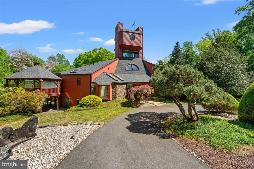 Set on nearly 7 acres in the coveted Mazza Woods enclave of Potomac, this extraordinary estate is a rare architectural offering designed by renowned modernist architect Roy Mason, celebrated for his distinctive use of glass, steel, and sculptural forms that blur the boundary between structure and landscape. Built in 1982 and offered for the first time, this one-of-a-kind residence spans approximately 6700 square feet and stands as a true work of art.
A long, private driveway winds through the trees, leading you to this quiet retreat. For those who wish to explore, the property unfolds into acres of forest, with a peaceful creek nestled at the base of the hillside, offering a natural sanctuary just steps from your door. The outdoor setting feels like an expansive private park, magically transforming with the changing seasons.
Inside, walls of glass frame panoramic views in every direction, flooding the home with natural light and creating a seamless connection to the lush, private surroundings. Soaring ceilings and an open floor plan on both levels make this an entertainer’s dream, while a dramatic three-story staircase leads to a breathtaking observation tower—an architectural centerpiece offering unmatched vantage points over the property.
Designed for both grand entertaining and intimate retreat, the home features 4 bedrooms and 3.5 baths, including a serene primary suite with its own sleeping porch—perfect for quiet mornings immersed in nature. The main level offers multiple seating and dining areas adorned with Murano light pendants, while the kitchen is equipped with granite countertops and high-end appliances. The lower level includes two additional bedrooms with a shared bath, plus an ensuite bedroom, and opens to a tranquil Zen garden, creating a peaceful sanctuary.
Outdoors, the property transforms into a private resort. A stunning in-ground pool anchors the grounds, surrounded by mature landscaping and specimen trees. The setting is alive with wildlife, including great blue herons, woodpeckers, blue jays, sandpipers, bald eagles, ospreys, and red-tailed hawks. Just a quarter mile from the C&O Canal towpath and the Potomac River, the location is both idyllic and inspiring.
Despite its secluded, oasis-like feel, this remarkable property is just minutes from Potomac Village shops and restaurants, with easy access to downtown Washington, D.C. Additional features include steel-frame construction and a two-car attached garage.
A truly special home that is architecturally striking, surrounded by nature, and perfectly suited for a lifestyle of beauty, privacy, and easy, relaxed entertaining.