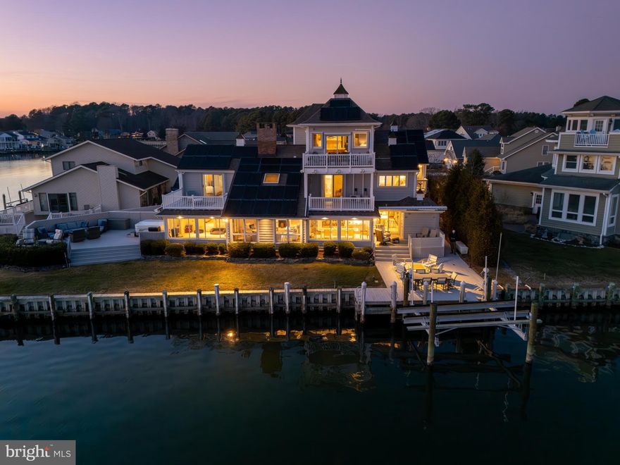 Welcome to a rare waterfront masterpiece on a premier point lot in Ocean Pines. Located at 26 W Mallard Drive on a quiet cul-de-sac, this exceptional direct bayfront coastal-style home offers breathtaking, unobstructed views of the Isle of Wight Bay and the Ocean City skyline. Built in 1983 and impeccably maintained, the residence spans just over 5,000 sq. ft. with 8 bedrooms and 8.5 baths, ideal for large gatherings or multi-generational living.

Designed to maximize waterfront living, the home features multiple balconies and expansive decks, an outdoor summer kitchen, hot tub, private pier with boat lift, and generous outdoor entertaining spaces perfect for hosting unforgettable bayfront gatherings. Inside, an elevator servicing up to the third level adds convenience and accessibility.

The chef’s kitchen is outfitted with 42” cabinetry, granite countertops, stainless steel appliances, multiple ovens, and a GE induction cooktop, complemented by an abundance of storage and prep space. Additional highlights include six refrigerators, a dedicated laundry room, 200-amp whole-house generator, storm shutters, four storage sheds, and an encapsulated crawlspace with dehumidifier and sump pump.

Situated within amenity-rich Ocean Pines, residents enjoy access to parks and recreation, aquatics, championship golf, marina, beach club, and more. This extraordinary bayfront property combines space, luxury, and lifestyle—an unparalleled opportunity on Maryland’s Eastern Shore.