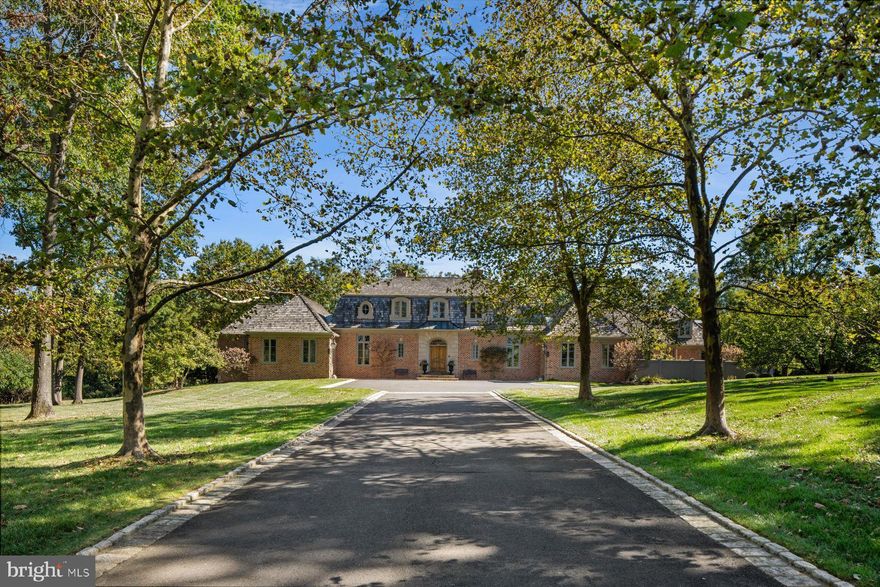 Nestled in Whitemarsh Township's prestigious Hunt Country on sought-after Sheaff Lane, this extraordinary custom estate offers the perfect balance of privacy, luxury, and comfort. Widely regarded as one of Montgomery County’s premier locations, the residence spans 7,000 square feet, thoughtfully designed by renowned architect Fred Bissinger and quality built by Parec. Situated on 3.3 acres of beautifully landscaped grounds and accessed via a gated entry, the property promises exclusivity and tranquility for its owners.
At the heart of the home is a state-of-the-art custom kitchen, expertly blending stunning design with superior functionality. Features include Village Hand Crafted Cabinetry, a six-burner dual-fuel Viking range, and two full-size Sub-Zero refrigerators. The well-appointed butler’s pantry adds convenience and style with its dedicated sink and additional custom cabinetry. Adjacent to the kitchen, a sun-drenched zen garden courtyard with raised garden beds and irrigation ensures a vibrant outdoor bounty throughout the year.
The gracious family room seamlessly connects to the kitchen and showcases handsome exposed beams and elegant built-ins, creating a welcoming setting for both daily living and gatherings. The formal dining room, living room, and study/library each feature their own fireplaces, offering inviting spaces for intimate gatherings or larger celebrations. Each of these rooms has direct access to the spacious rear blue stone patio, blending indoor comfort with exceptional outdoor living and entertaining space.
The primary suite serves as a luxurious retreat on the far wing of the main floor, complete with a spa-like marble bathroom. An additional ensuite bedroom on the same level is ideal for guests or multi-generational living. The main floor also includes a spacious laundry room and a mudroom equipped with a custom dog shower and custom cabinetry. Two powder rooms and numerous closets throughout the home provide functional convenience and generous storage.
Ascending to the upper level via antique handmade iron stair rails from the 19th century reveals two spacious bedroom suites, each with professional closet systems and custom window seats. The upper level also features a large gathering room, redesigned with built-in work stations and numerous built-ins —perfect for study, work, or relaxation. Above the garage, an au-pair suite or office includes a living area, bedroom, kitchenette, full private bathroom, hardwood flooring and separate entrance.
Outdoor living is elevated with over 3,000 square feet of blue stone patios, a state-of-the-art Aqua Bella swimming pool with spa and automatic cover (installed in 2016), a stone fire pit with natural gas, and breathtaking professional night scaping.
Additional highlights and modern comforts include custom built-ins throughout, arched doorways, an oversized three-car garage with epoxy floor, an additional one-car detached garage, a smart security CCTV system, cellular entry gate operations system, new well (installed in 2017), reverse osmosis water system, whole-house natural gas generator, and HVAC units with five zones (2017). These features ensure comfort and connectivity at every turn.
This unique property is being offered fully furnished. The location is A+ with offers easy access to fine dining, shopping, major routes including the PA Turnpike, Blue Route, and several regional train lines. Truly a special property not to be missed.
