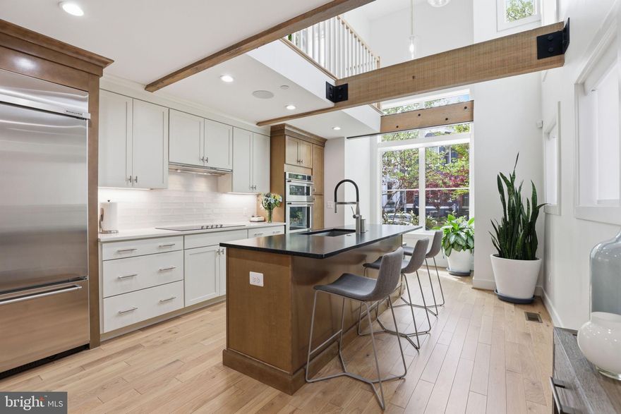 Tucked along a quiet, tree-lined stretch in DC’s coveted Logan Circle, 1007 O Street NW is the kind of home that stops you mid-scroll. Crafted in 2021 by OPaL, this custom-built townhome is a refined statement of design, where every detail feels intentional and elevated.

From its striking architecture to its effortlessly livable layout, the home is both a showpiece and a sanctuary. Floor-to-ceiling windows flood the interiors with light, illuminating true hardwood floors, custom paneling, and a seamless flow anchored by an oversized great room with acoustic detailing. At the heart of the home, a dramatic double-height kitchen stuns with exposed beams, bespoke cabinetry, gourmet appliances, a walk-in pantry, and a generous island that opens to a cozy breakfast nook—perfect for both quiet mornings and lively gatherings.

With 3 bedrooms, 2 flexible dens, and a lofted workspace overlooking the kitchen, the layout adapts beautifully to modern living.  The primary suite is its own retreat, complete with a private balcony, walk-in closet, and spa-like water room with soaking tub and separate shower. The reimagined third level offers a bright secondary suite, an expanded third bedroom with a skylight and a stylish full bath with dual vanity and pocket doors.  

Three private outdoor spaces—including a patio, balcony, and an expansive rooftop deck with sweeping city views—extend your living experience. Add in off-street parking, a pre-wired sound system, state-of-the-art security, abundant storage, and bedroom-level laundry, and every convenience is accounted for. A nominal HOA keeps things effortless, covering snow removal, trash, and entry security.

This isn’t just a place to live—it’s a place to feel something. And in Logan Circle, opportunities like this don’t come around often.