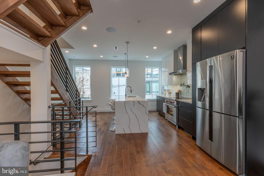 **$6,000 Limited-time Lender Incentive Available towards Buyer's Closing Cost, Please contact Gianna with any questions **Welcome to 1111 Dunton Street — an absolutely jaw-dropping, 18 ft-wide new construction home offering 2,700 sq ft of luxury in the heart of Northern Liberties/Fishtown. This 4-story residence features 4 spacious bedrooms, 4 full bathrooms, a fiberglass roof deck with unobstructed skyline views, and 6 years remaining on the tax abatement. Step inside to a bright and spacious foyer level, complete with a full bathroom, coat closet, storage closet, and a large first-floor bedroom—perfect for guests, an office, or an in-law suite. This level also provides access to your private, fenced-in backyard, just in time for summer BBQs or quiet evenings outdoors. Upstairs, the show-stopping kitchen awaits. Enjoy an 8 ft Carrara waterfall island, white upper and matte black lower cabinetry, subway tile backsplash, matte black pot filler and fixtures, and a high-end Wolf appliance package with induction cooktop. The adjacent dining area and expansive living room feature tray ceilings and sliding glass doors leading to a private deck, creating the perfect indoor/outdoor flow. The third level is dedicated to the primary suite—a generous bedroom with a walk-in closet and a breathtaking spa-like bathroom, featuring a freestanding soaking tub, oversized shower with matte black fixtures, marble finishes, and a dual floating vanity. On the fourth level, you’ll find a convenient laundry room, a beautiful hall bath, and two additional bedrooms, each with en-suite bathrooms, great closet space, and incredible natural light from oversized windows. The secondary bathrooms showcase floating vanities, sleek lighting, and refined modern finishes. At the top, a stylish dry bar with wine fridge welcomes you before stepping out to your private roof deck—offering stunning unobstructed views of the Center City skyline, the Fishtown mural, and the Ben Franklin Bridge. It’s the perfect backdrop for entertaining, relaxing, and enjoying everything this neighborhood has to offer. Located in one of Philadelphia’s most vibrant pockets, you’re just steps from top-tier dining, bars, nightlife, and entertainment. Local favorites include The Fillmore, Fabrika, Fishtown Brewpub, the Frankford Ave corridor, and so much more. Easy access to highways and bridges makes commuting a breeze. Don’t miss your chance to own this exceptional home—schedule your private tour today!