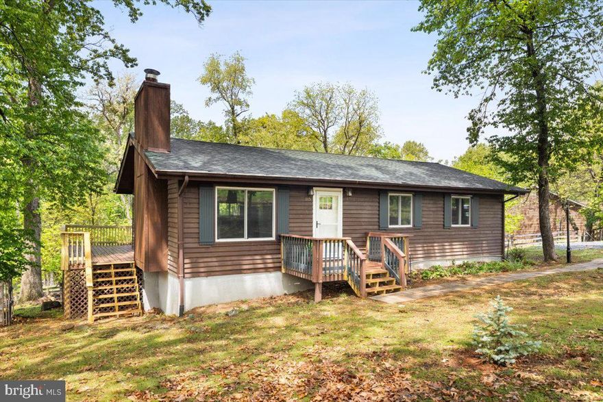 Situated in the serene, gated community of High Knob, this inviting ranch-style home blends rustic charm with modern comfort. Built in 1981 and clad in recently stained classic cedar siding, 115 Split Rail Road features 3 bedrooms, 2 full bathrooms, and a partially finished lower level—ideal for extended living space, a workshop, or generous storage.
Inside, vaulted ceilings and an open-concept layout create a light, airy feel, while exposed beams and a cozy wood stove add warmth and character. Over the past several years, thoughtful updates have enhanced the home’s comfort and efficiency, including new windows, attic insulation, a new wood stove and chimney, a water heater, and updated kitchen appliances. For added peace of mind, the HVAC was replaced in 2019, and the roof is approximately seven years young.
The lower level, previously used as a family room and workshop by the current owners, offers flexibility and functionality to suit a variety of needs.
Outdoor living is just as appealing, with a spacious rear deck perfect for entertaining or relaxing while taking in the mountain views. The fenced backyard is great for pets, and the circular driveway adds everyday convenience.
As part of the sought-after High Knob community, residents enjoy exclusive amenities including a clubhouse, seasonal swimming pool, tennis court, playground, and direct access to the Appalachian Trail. The location offers the best of both worlds—peaceful mountain living with easy access to I-66 for commuting.  **Some photos have been virtually staged so you can see the possibilities.