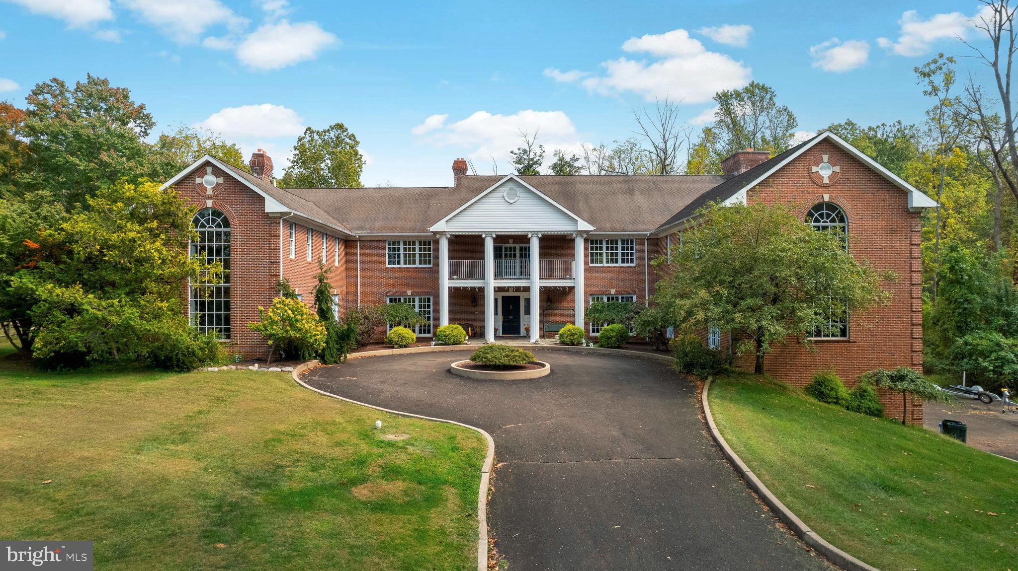 Welcome to this extraordinary estate, gracefully situated on over 3 acres in the prestigious Deer Run Farms community within the highly acclaimed Council Rock School District. From the moment you arrive at the long, private driveway, the sweeping grounds and timeless curb appeal set the tone for a residence that is both elegant and inviting. A bluestone covered front porch offers a stately welcome to this remarkable home, where rich history meets modern luxury.
This expansive property boasts six bedrooms, six full bathrooms, and five powder rooms, seamlessly blending character, comfort, and style. A special highlight of the estate is the beautifully preserved circa 1771 residence that connects directly to the main home. Overflowing with charm, the historic wing features a living room with a wood burning fireplace, a kitchen, and a powder room on the first floor; two bedrooms and a full bathroom on the second floor; and a third-floor loft primary bedroom with skylights.. The character and craftsmanship of this space add a truly unique dimension to the estate.
The main residence offers grandeur at every turn, beginning with a spacious living room anchored by a wood-burning fireplace and a parlor currently enjoyed as a billiards room. The kitchen is designed for both cooking and entertaining on a grand scale, with tile floors, two large islands, a Viking stove and dishwasher, two kitchen sinks, an additional prep sink, and French doors that open to the yard. Upstairs, three additional bedrooms each offer their own en suite bathroom, while a conveniently located laundry room completes the second floor. The primary suite is an expansive retreat, filled with natural light from walls of windows and featuring its own wood burning fireplace, a large sitting room overlooking the property, and a spa like bathroom with a Jacuzzi tub, two separate water closets, dual vanities, a stall shower, and two expansive walk-in closets.
The lower level offers endless possibilities, with a large finished basement anchored by a striking River rock wood burning fireplace, ideal for creating a custom recreational suite. A four-car garage with 9-foot doors provides ample parking and storage.
Outdoors, the property continues to impress with a heated pool and separate spa, complemented by a beautifully designed pool house complete with a living room, kitchen, and full bathroom, perfect for entertaining or guest accommodations. The expansive grounds provide both privacy and space to create the ultimate outdoor sanctuary.
Blending historic charm with modern luxury, this residence offers everything you could possibly need, while still providing the opportunity to add your own personal touches. Truly a once-in-a-lifetime offering, this estate is a rare gem in one of Bucks County’s most desirable locations.