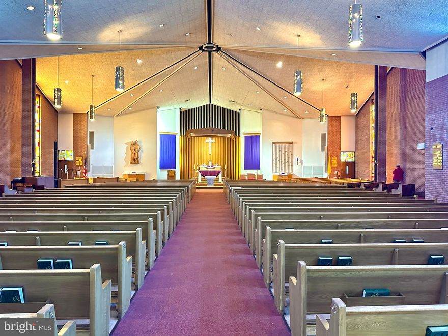 Rarely available -- house of worship with a seating capacity of 550. The former St Rose of Lima religious complex includes a church with hall, a large detached rectory, a two-stall garage, and paved parking on ±1.04-acres.
The church, totaling 21,718 SF, offers a sanctuary, sacristy, two small offices, and storage on the main level.  Although the sanctuary seats 550 in pews, the seating configuration also allows for a more intimate worship service, by using the seating that occupies the front and side areas nearer to the altar.  The lower level of the  church was originally built as a second worship space, complete with an altar area, room for seating, and a sacristy.  The worship area has since been reconfigured into a hall, and three sizable classrooms, which had previously been used for kindergarten and pre-K.  The space could easily be restored to a large multi-purpose room, or further divided to create additional office, meeting, or classroom space.  The lower level also include restrooms, mechanical room, storage rooms, and additional ministry space.  
Built in 1968, of brick and precast concrete, the church has central heating and cooling, with water boiler, chiller, and cooling tower serving air handlers and radiators. The building systems were operational when last in service. 
The rectory, totaling 8520 SF, was the former home of the priests who served the parish.  Built in 1920, the four-level home includes a main kitchen, living room, numerous offices, bedrooms, bathrooms, and an upper-level kitchenette.  The rectory, given its size and number of rooms, could be used for a variety of ministry-related activities:  administrative offices, meeting spaces, education, youth ministry, food pantry in the basement.  It could also provide an opportunity for additional revenue streams.  The rectory is served by a central boiler, along with split system units, and window A/C units.
Located in the Brooklyn neighborhood of Baltimore, the complex offers easy access to I-895 and Route 2--creating the ability to draw members from surrounding counties.  The property will be sold as is. There is no option to lease. Some chattels will convey, but most religious items will be excluded from the sale.  To request a showing, please have your real estate professional book through ShowingTime.
