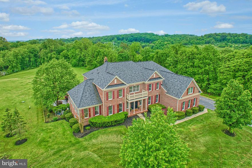 Stately with distinctive charm and sensational pastoral views, this inviting executive retreat blends elegance and tranquility, offering an unparalleled lifestyle at the crossroads of wine country and bustling Leesburg. Beyond its handsome brick-wrapped welcome, 9,466 square feet line spaces for rest, work, and entertaining with honey-hued hand scraped floors, effortless trimmings, tray ceilings, and sun-lit windows. While, at its heart, a stunning imperial staircase welcomes and captures life’s picture-perfect moments, your gourmet kitchen is a gathering point of high-end appliances, soft-close cabinetry, and luxe hardware for assisting the chef. Prepare weeknight favorites for the breakfast nook and finish desserts for guests enjoying 6.43 acres of treelined views where professional landscaping creates a sense of space for the pool, spa, and screened-in porch. Here, host the season’s best poolside parties, lounge-away a Saturday, and dine under the stars. Five sunkissed bedrooms partner with over five modern baths for rest and recovery. Loved ones will appreciate the privacy of en suite accommodations, while in the primary suite, an oversized shower and centerpiece place for bubbles awaits. While multiple living vistas create perfect havens for play, hobbies, and quiet reads, your finished walkout basement boasts room for game nights, morning yoga, and hosting overnight guests. While on tour, visit the three-car garage where you’ll launch W&OD trail adventures, and ask about the home’s fresh hues and additional updates. From home, Route 7 and the Greenway lead to Historic Leesburg and Purcellville, while rolling Hunt and Wine Country awaits.