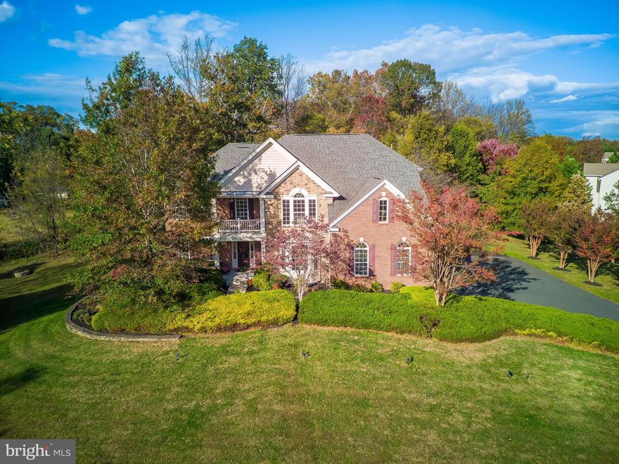 Discover the perfect balance of elegance, comfort, and privacy in this stunning home, set on a premium 1.54-acre lot that backs to tranquil trees. Just minutes from modern day amenities, this estate offers the serenity of country living with effortless access to the best that Loudoun County has to offer.

Incredible financing opportunity - this home offers an assumable VA loan at 2.5% interest rate (please inquire with listing agent for remaining balance and terms)!

A welcoming front walkway leads to a covered porch and a grand two-story foyer, instantly setting the tone for a home designed with both style and thoughtful flow. Front and back stairwells connect every level, creating a sense of continuity and ease.

The main level is an entertainer’s dream. Natural light fills the study through French doors and a bay window, offering an ideal space for working from home. The formal living and dining rooms feature rich hardwood floors and intricate moldings, while the gourmet kitchen is a chef’s delight with granite countertops, a center island with breakfast bar seating, and premium stainless steel appliances. The breakfast area opens to a covered screened porch and Trex deck overlooking the expansive backyard, creating a perfect setting for morning coffee or evening gatherings with family and friends. The family room flows seamlessly from the kitchen and centers around a striking floor-to-ceiling stone gas fireplace and coffered ceiling. Surround sound and an intercom system throughout the home elevate both comfort and convenience. A mudroom drop zone, a laundry and sorting room with utility sink, and a freshly painted three-car garage with epoxy floors complete the main level.

Upstairs, the primary suite is a true sanctuary. Double doors open to a vaulted sitting room with a private porch. The spa-like bath features dual vanities, soaking jetted tub, walk-in shower with bench, and his-and-her walk-in closets. Three additional bedrooms each offer walk-in closets, en suite or Jack-and-Jill bathrooms. A vaulted loft provides flexible space for reading, play, or relaxation.

The lower level offers a fully finished retreat with a spacious walk-out recreation room, wet bar with seating, wine storage and tasting nook, and a private guest suite. With LVP flooring, recessed lighting, and elegant finishes, this level is ideal for entertaining or relaxing in comfort.

Outside, the expansive backyard features an in-ground irrigation system and endless possibilities for recreation or gathering. The property’s location enhances its appeal, providing the feeling of peaceful countryside living while still being close to everything. Easy access to Washington Dulles International Airport and major commuter routes like Route 50 and Route 15 make travel throughout Northern Virginia and the DC Metro area convenient. Everyday essentials such as grocery stores, restaurants, movie theatres, libraries and shopping centers are within easy reach, including Brambleton Town Center and the Village at Leesburg. Outdoor enthusiasts will love the proximity to the 257-acre Hal and Berni Hanson Regional Park with sports fields, trails, and open green spaces. Weekend outings to charming Middleburg with it's endless wineries and breweries, downtown Leesburg, local farmers markets, and Loudoun County’s scenic vineyards are all just a short drive away.

Key updates include fresh paint throughout (2025), LVP floors in the basement (2025), carpet on front stairwell (2025), fresh landscaping (2025), 

This exceptional property combines privacy, luxury, and convenience in a setting that truly feels like hom!