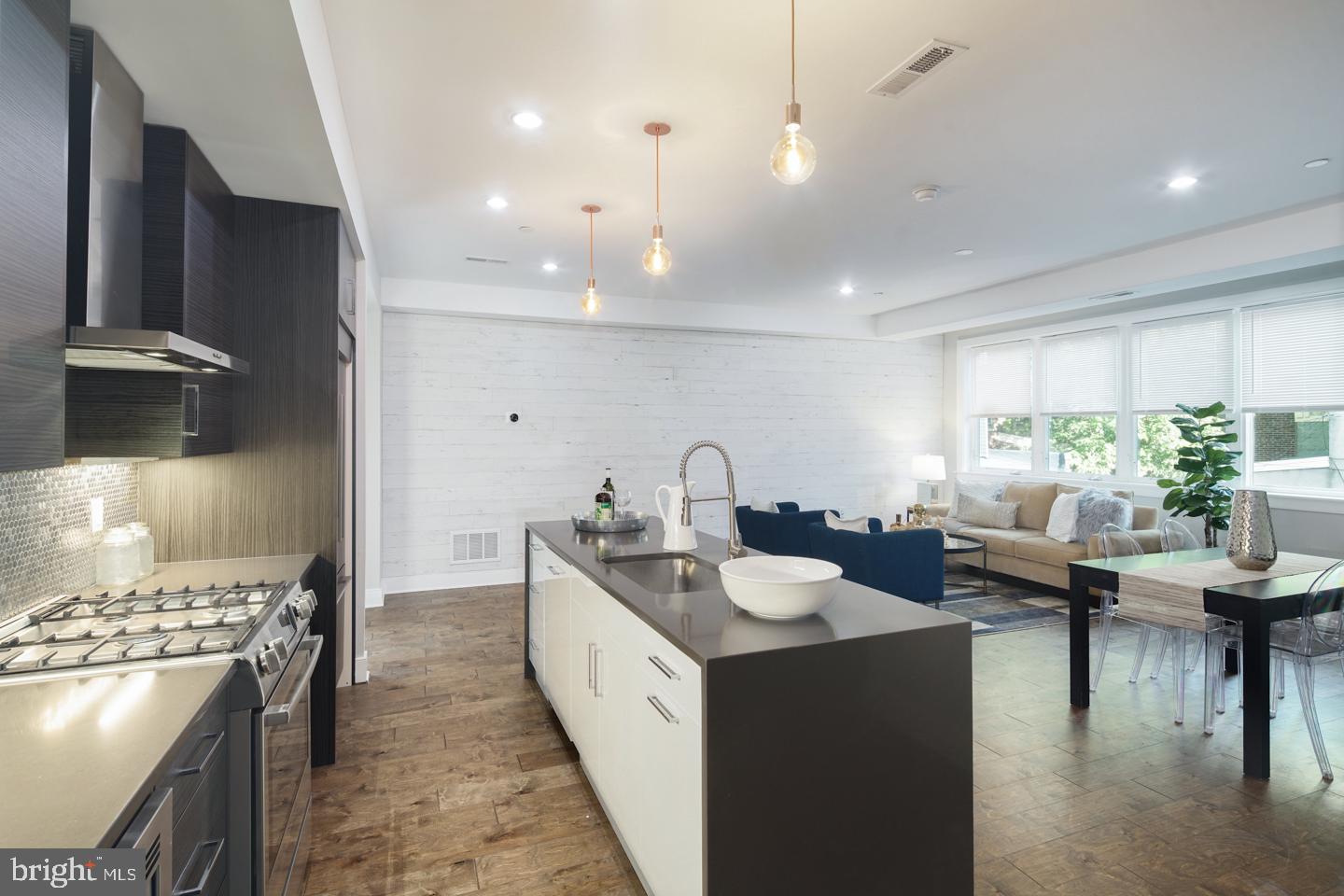 Absolutely stunning and extra-wide 24-foot home in the heart of Fishtown, offering 3 spacious bedrooms, 2 full bathrooms, 2 half bathrooms, and a TWO-CAR garage with built-in storage. This exceptional residence also features a private roof deck with skyline views, multiple outdoor spaces, and a fully finished basement. The main level is bathed in natural light and showcases a bright, open-concept layout with gorgeous hardwood floors throughout. The spacious living and dining areas flow seamlessly into the modern kitchen, which is outfitted with generous cabinet and counter space, a stylish island with bar seating, and direct access to a private rear deck. Upstairs, the primary suite is a true retreat with its own private deck, a luxurious en-suite bath, and an oversized walk-in closet. Two additional bedrooms and another full bath complete the upper levels. Topping it all off is the expansive roof deck—your own private oasis with sweeping views of the city skyline. Square footage includes above and below grade. Taxes and square footage is the buyer responsibility to have verified independently. Abatement ends 1/31/2029.